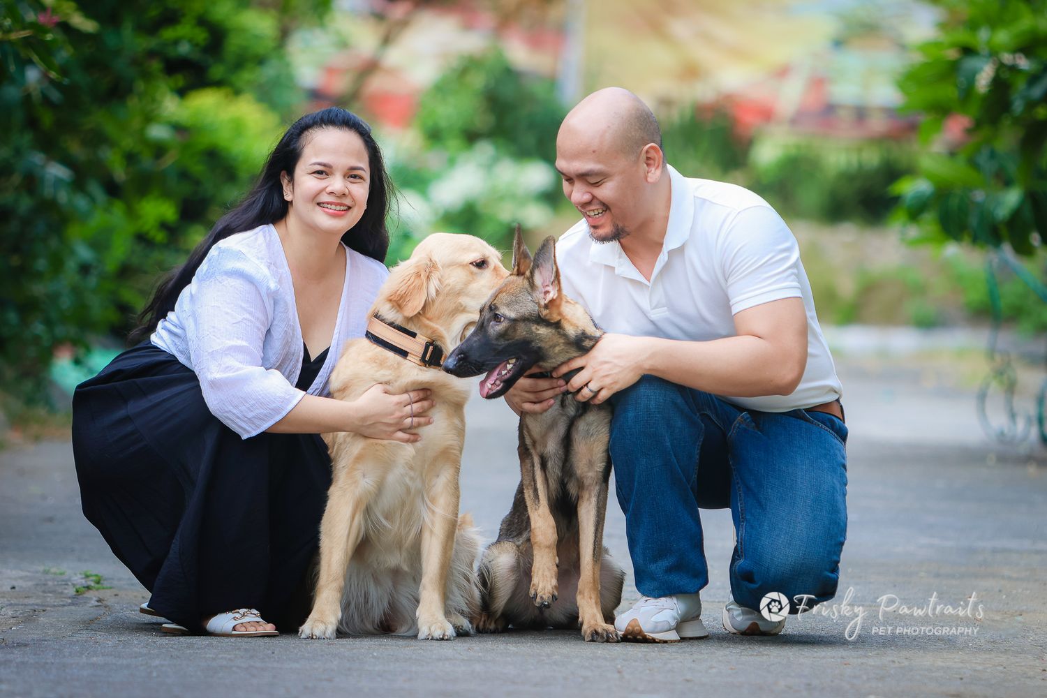 outdoor portrait of a human couple with their dogs