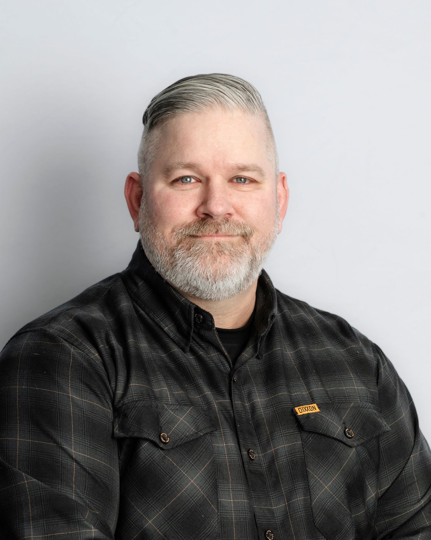 Series of headshots showing different angles of person in black plaid shirt against white backdrop.