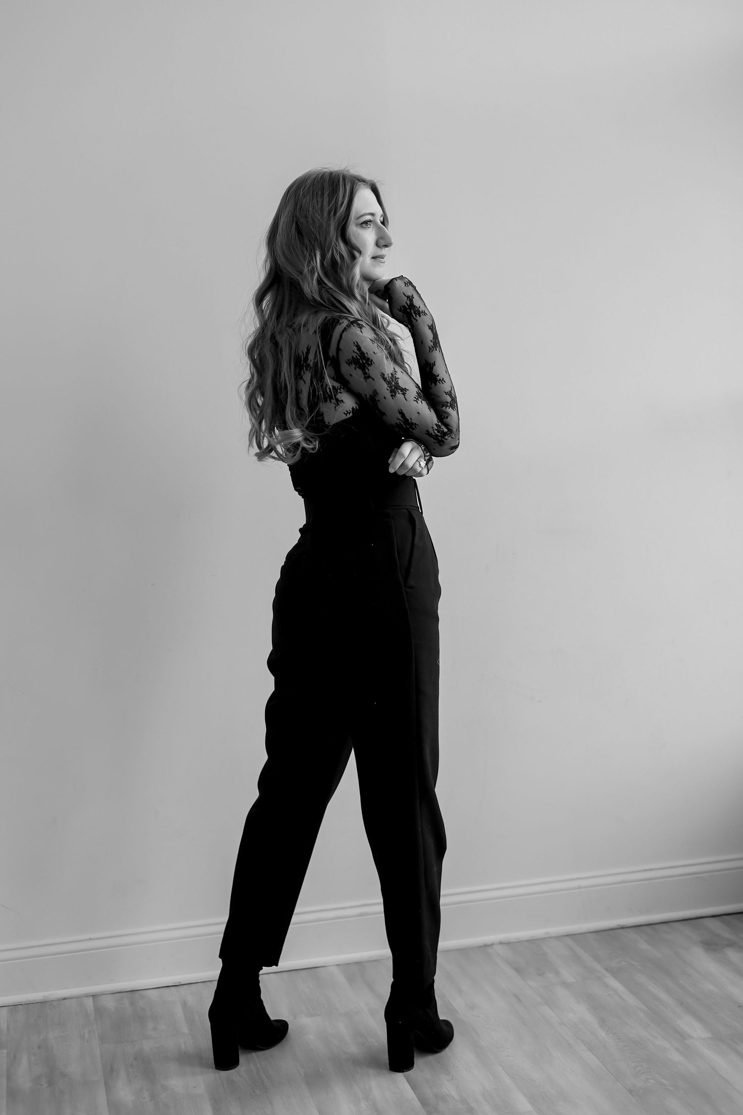 A black and white photo series showing a person in dark clothing moving against a white wall in four dynamic poses.