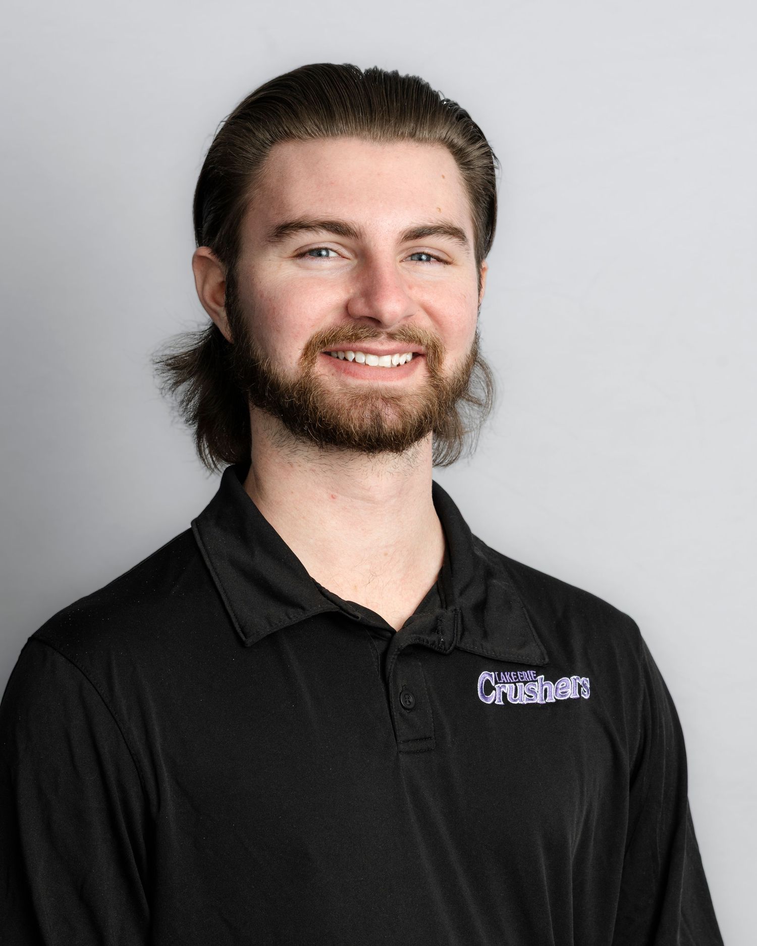 Portrait series of a bearded person in a black polo shirt against a light background.