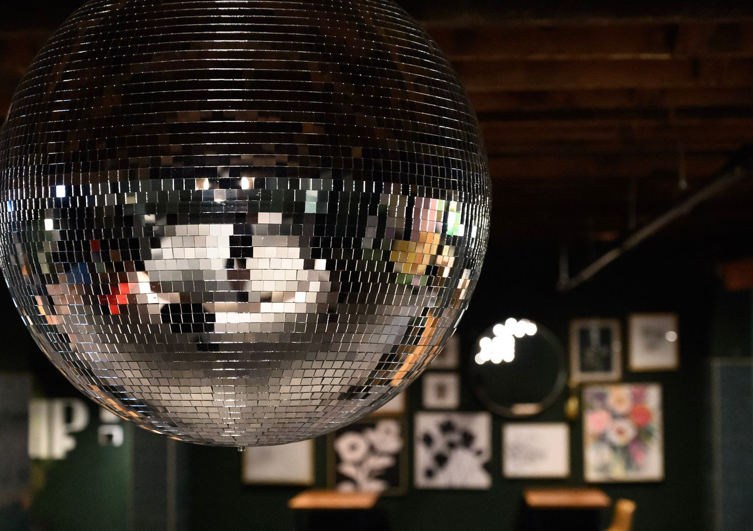 Large disco ball reflecting light in a dimly lit venue.