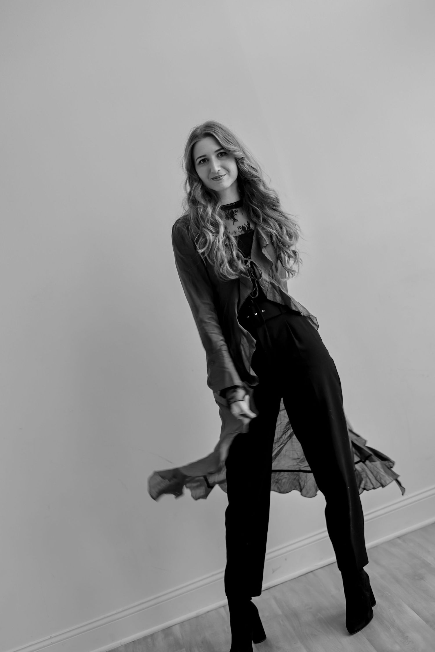 A person in black clothing poses dynamically against a gray wall in a series of artistic fashion shots.