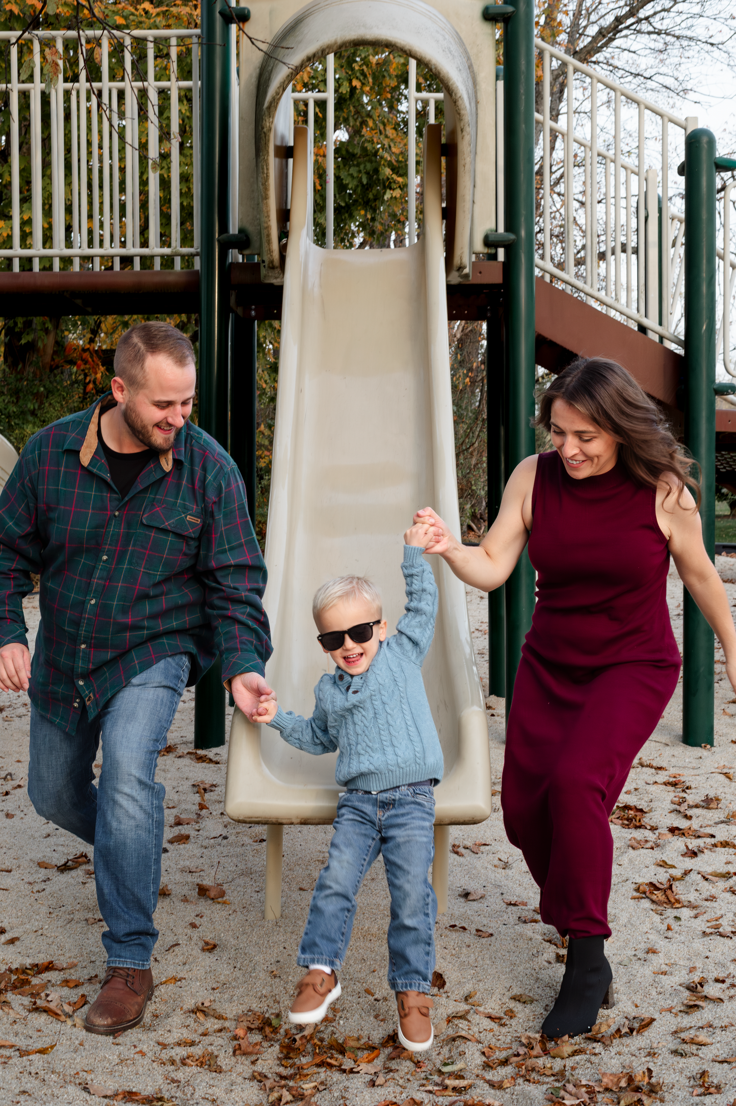 A series of playful moments on a playground slide with fall leaves scattered on the ground.