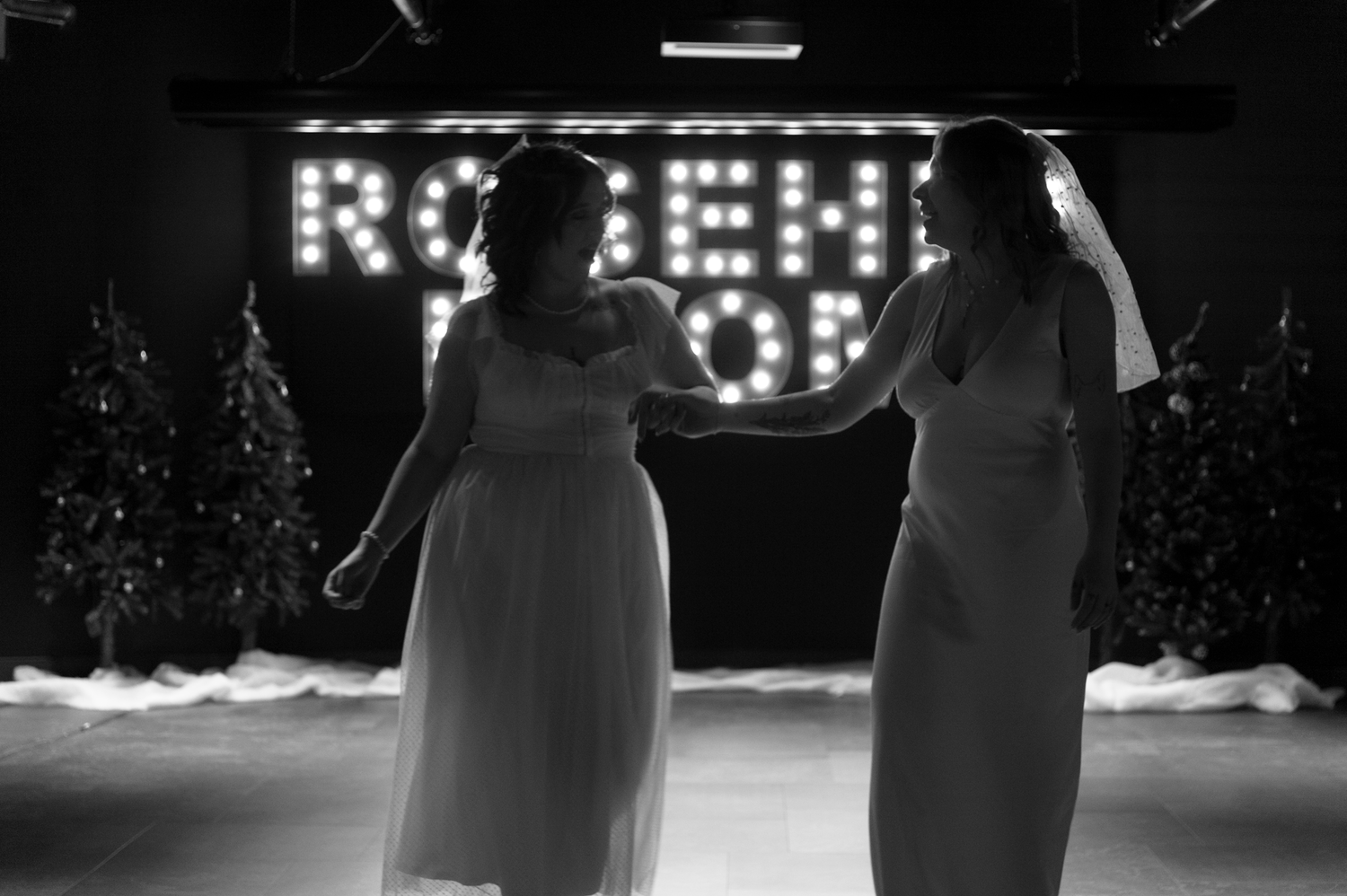 Performers dance in dramatic silhouette against bright stage lighting.