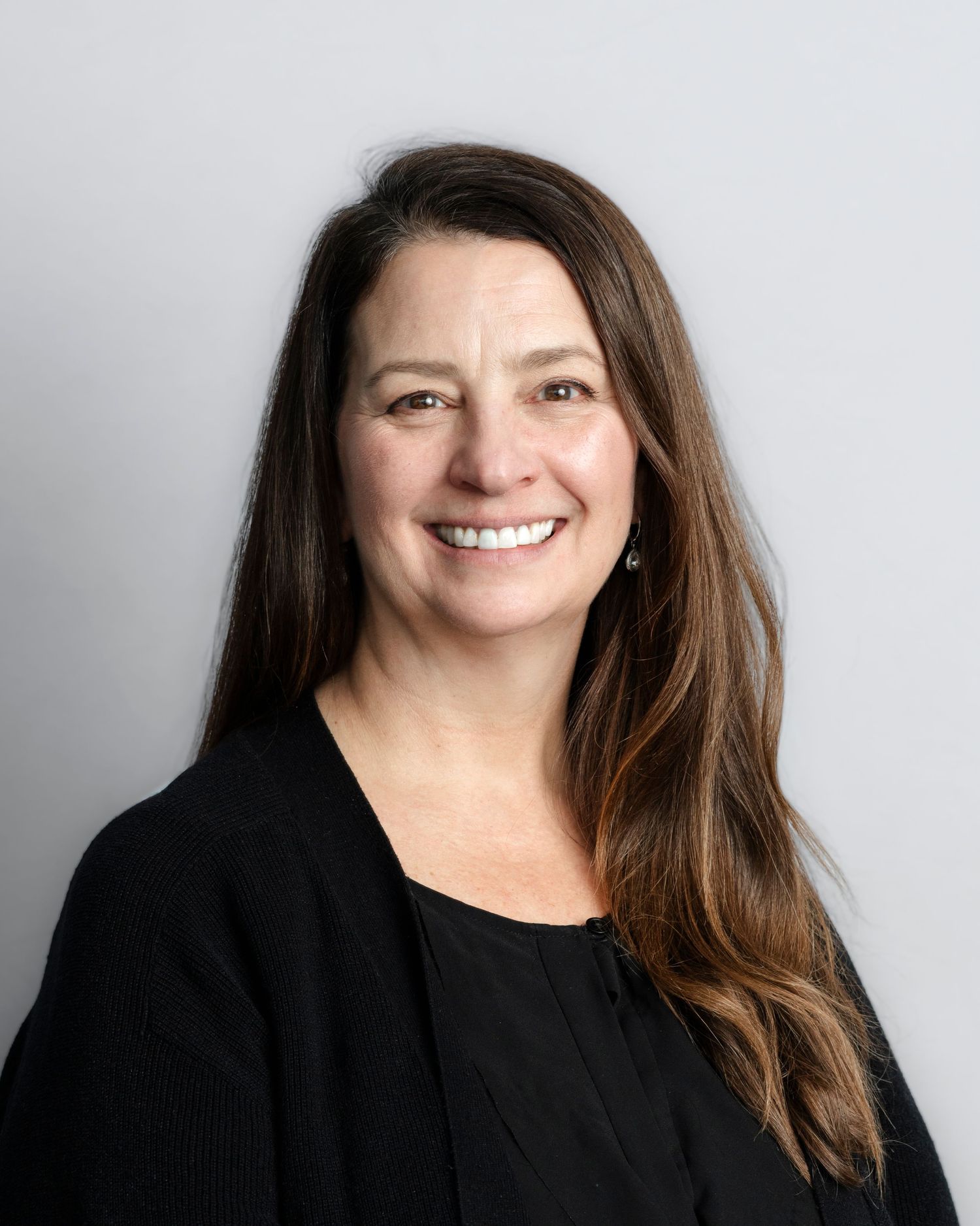 Progressive headshots of someone wearing black smiling against neutral background.