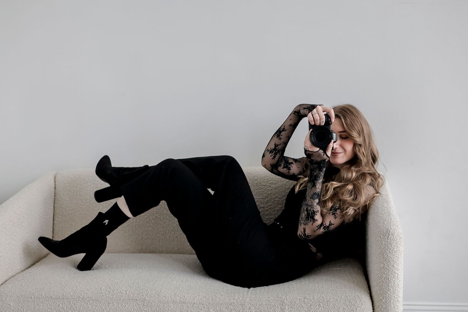 A black and white photo series showing a person in dark clothing reclining on a light colored sofa.
