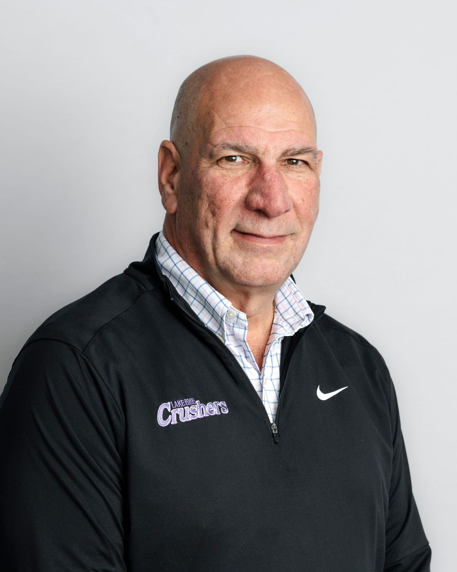 Professional headshots of a person in a black Nike jacket against a light gray background.