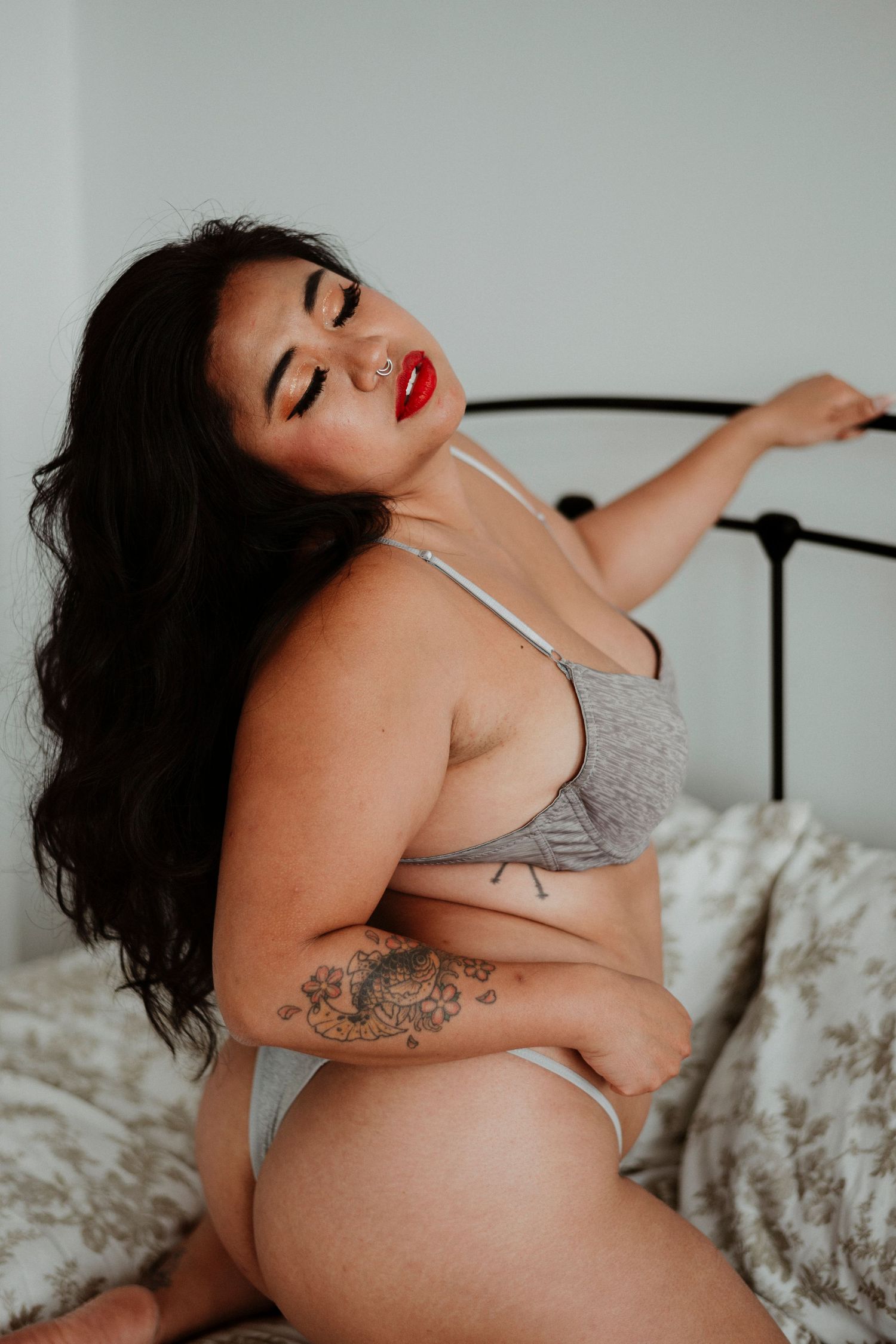 A series of boudoir photos showing a person in gray lingerie posing on a bed with white bedding.