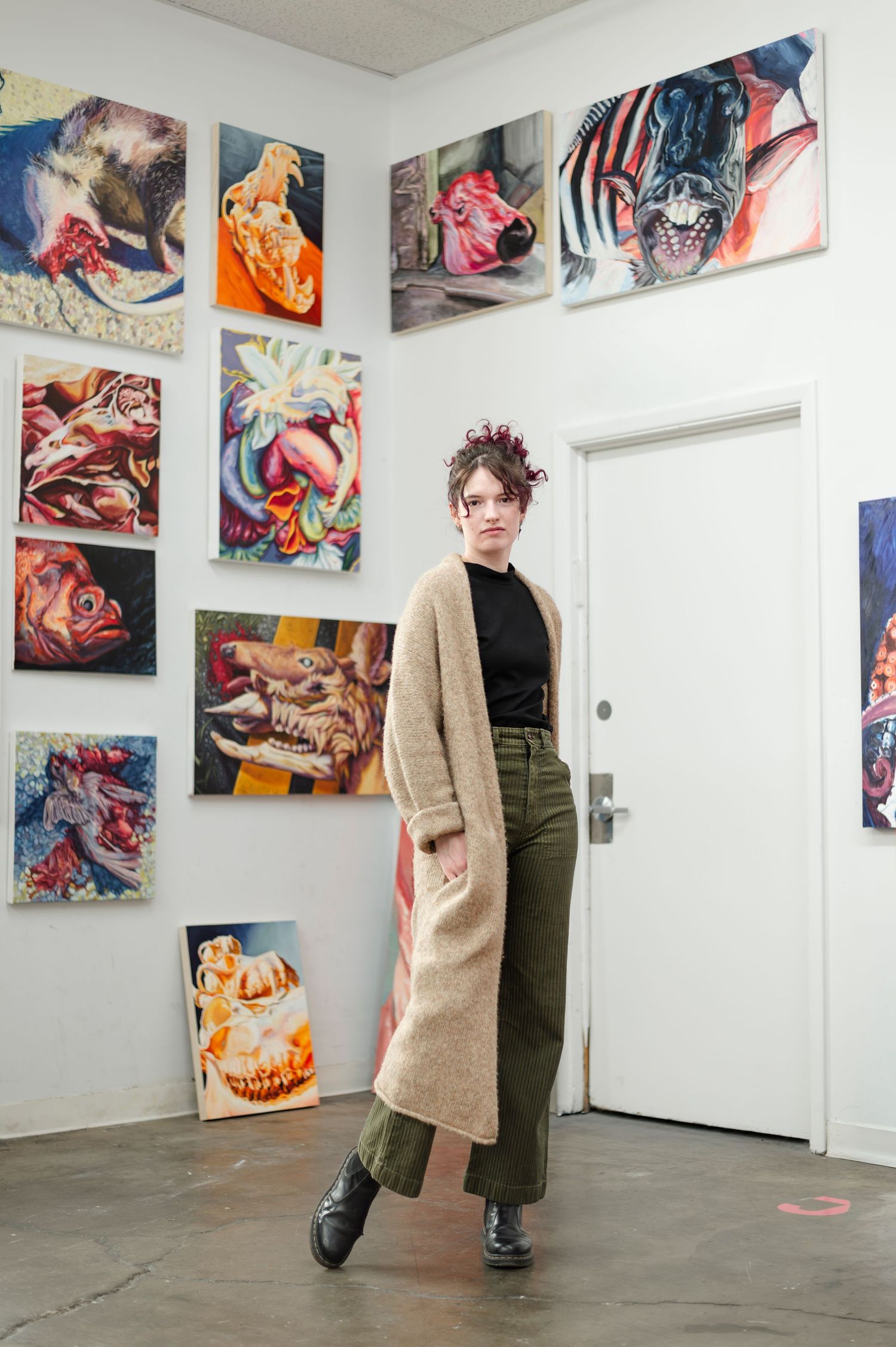 Art gallery space with colorful abstract paintings displayed on white walls.