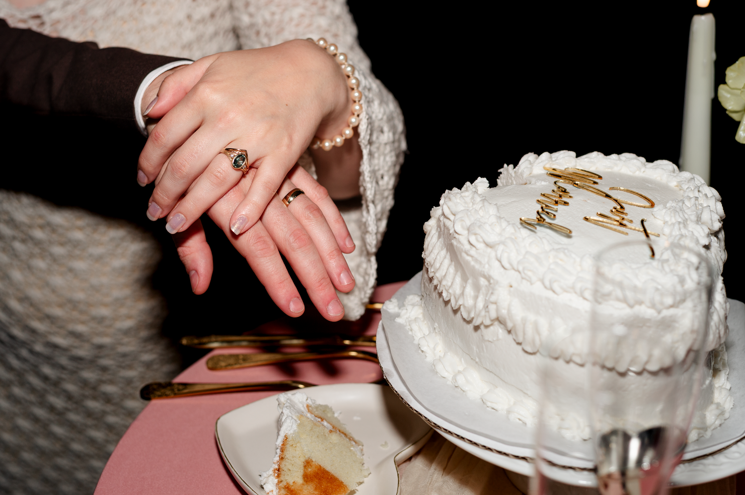 A white wedding cake being cut and served at a reception celebration.