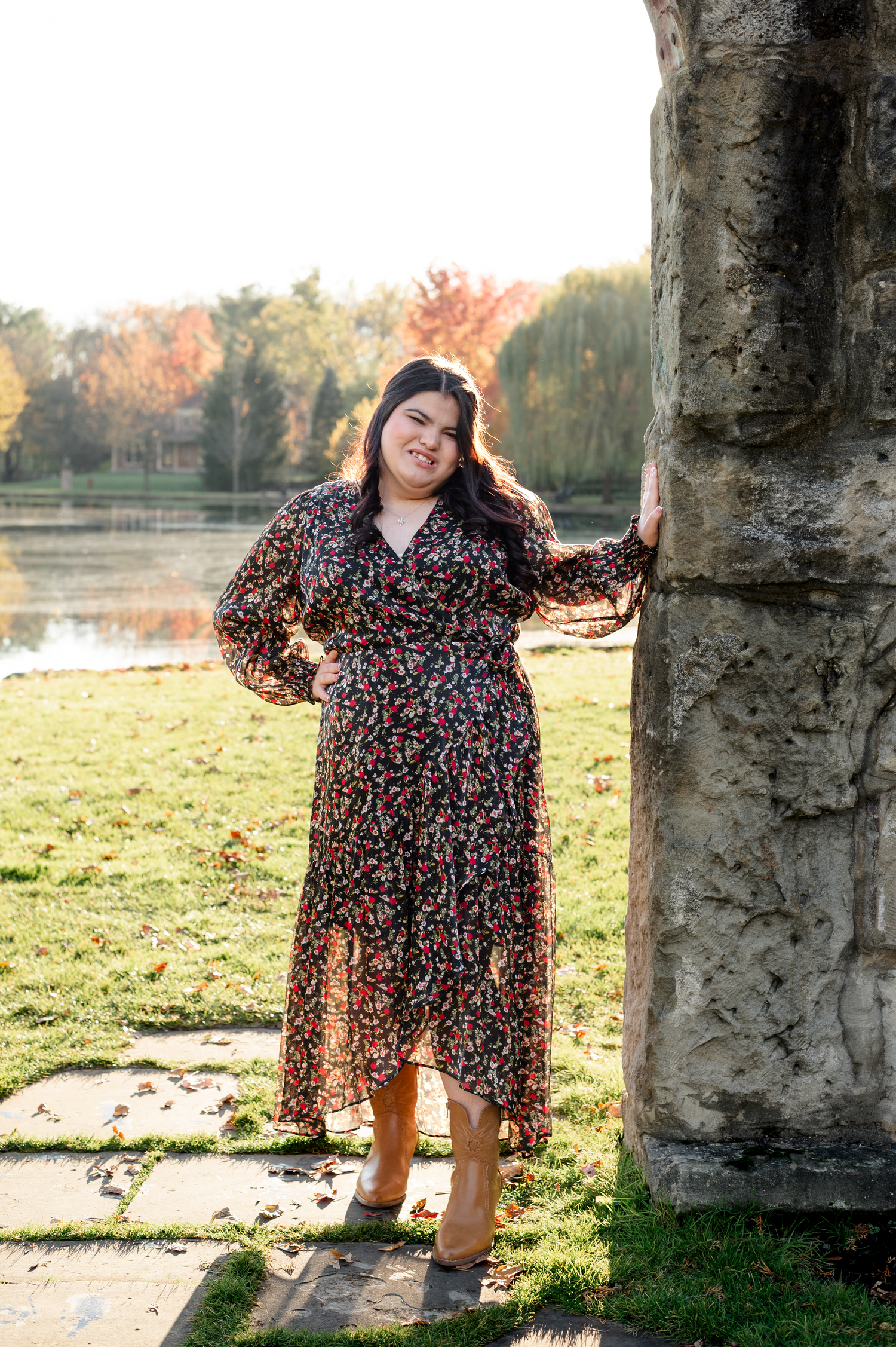 Four artistic outdoor photos show a floral dress against stone pillars with autumn trees and a lake in the background.
