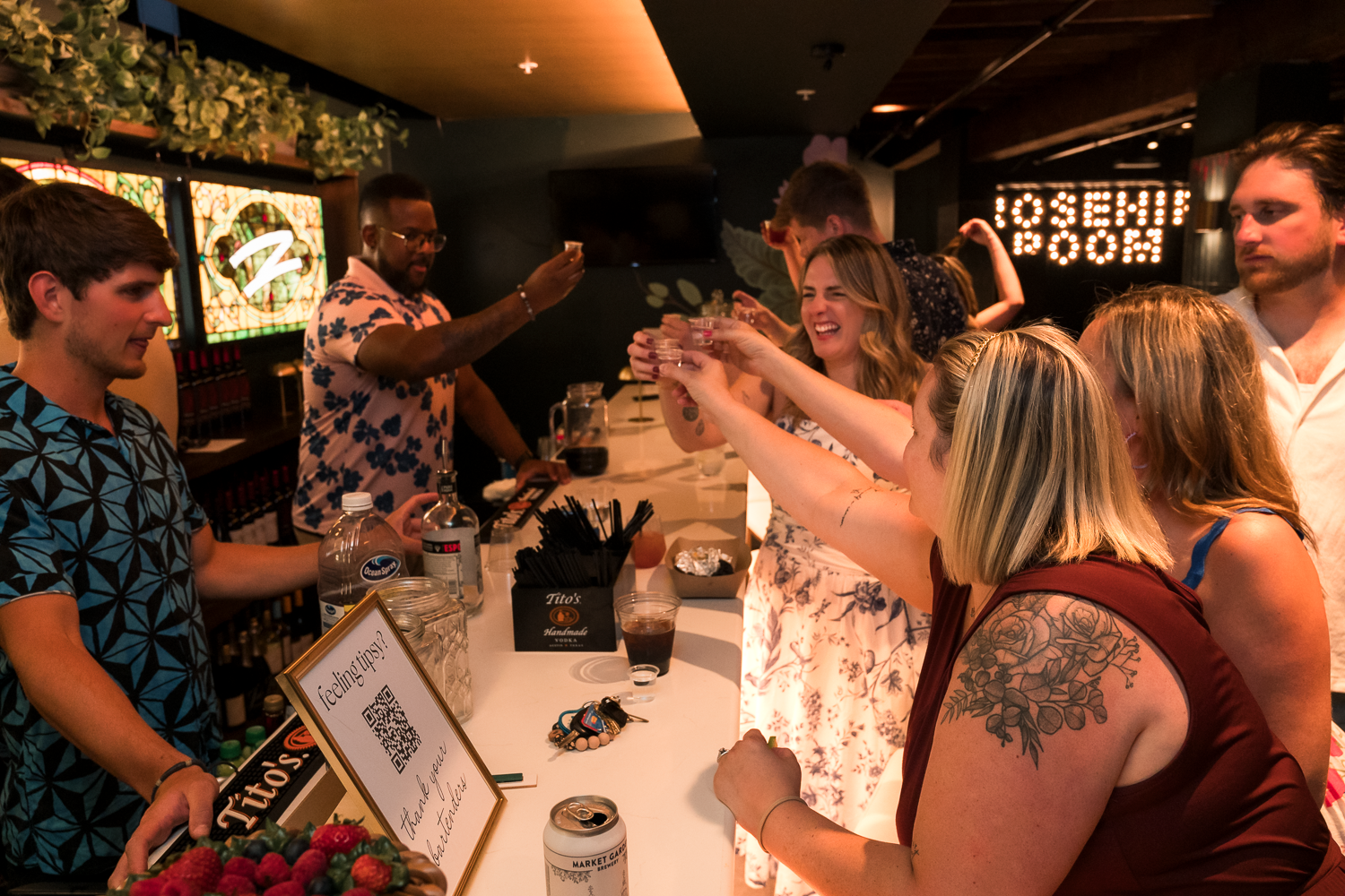 A group of people gather around a table at a dimly lit restaurant or bar for a social event.
