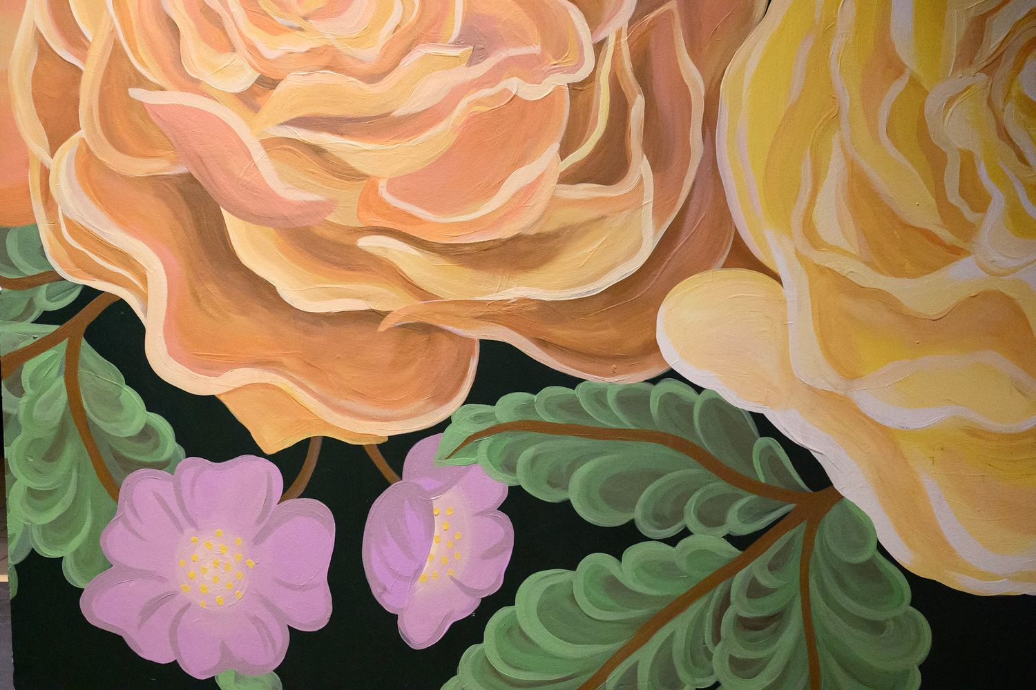 Delicate floral border with peach and yellow roses alongside green foliage.