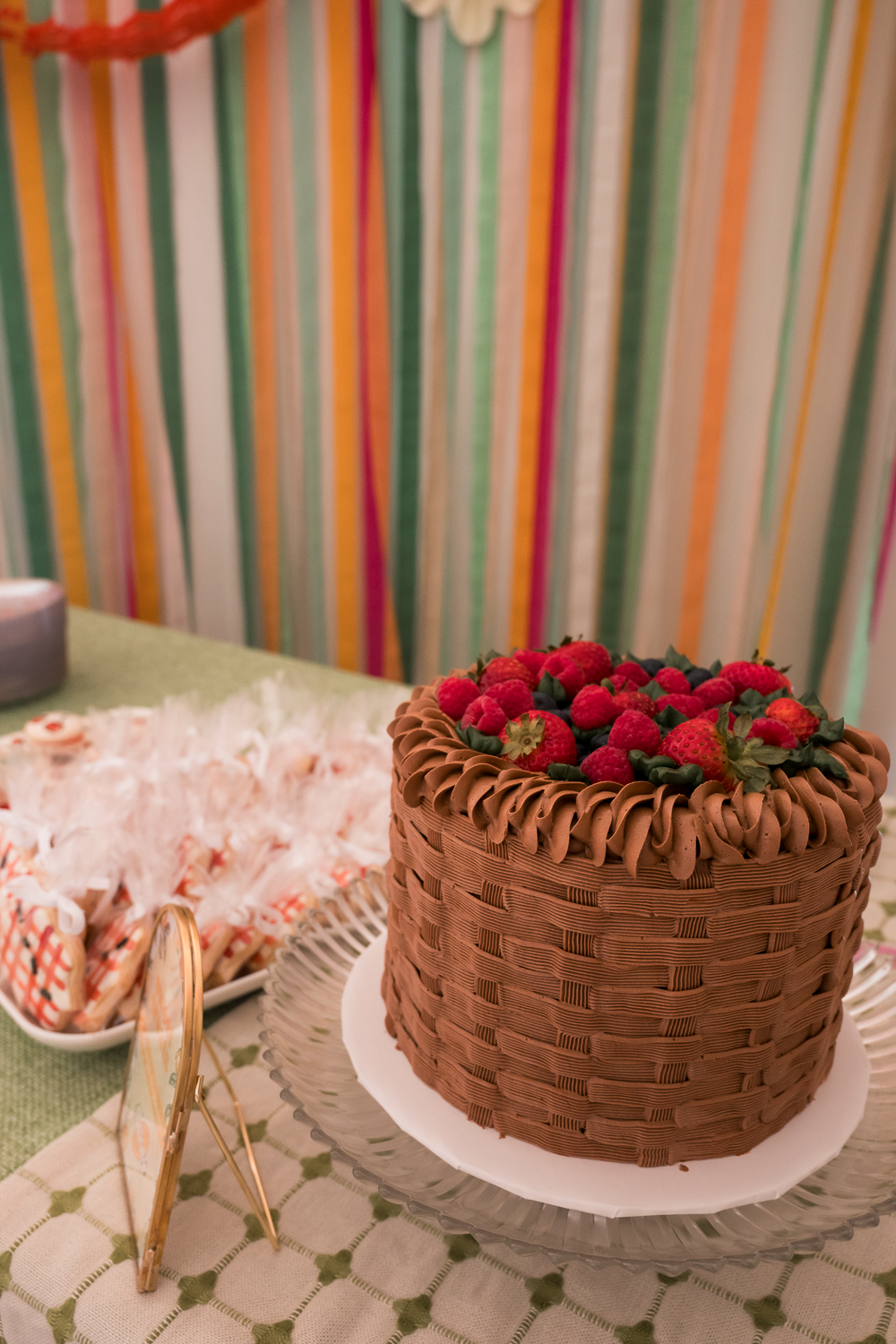A series of chocolate cakes with basket weave frosting patterns and red berry decorations displayed on white plates.