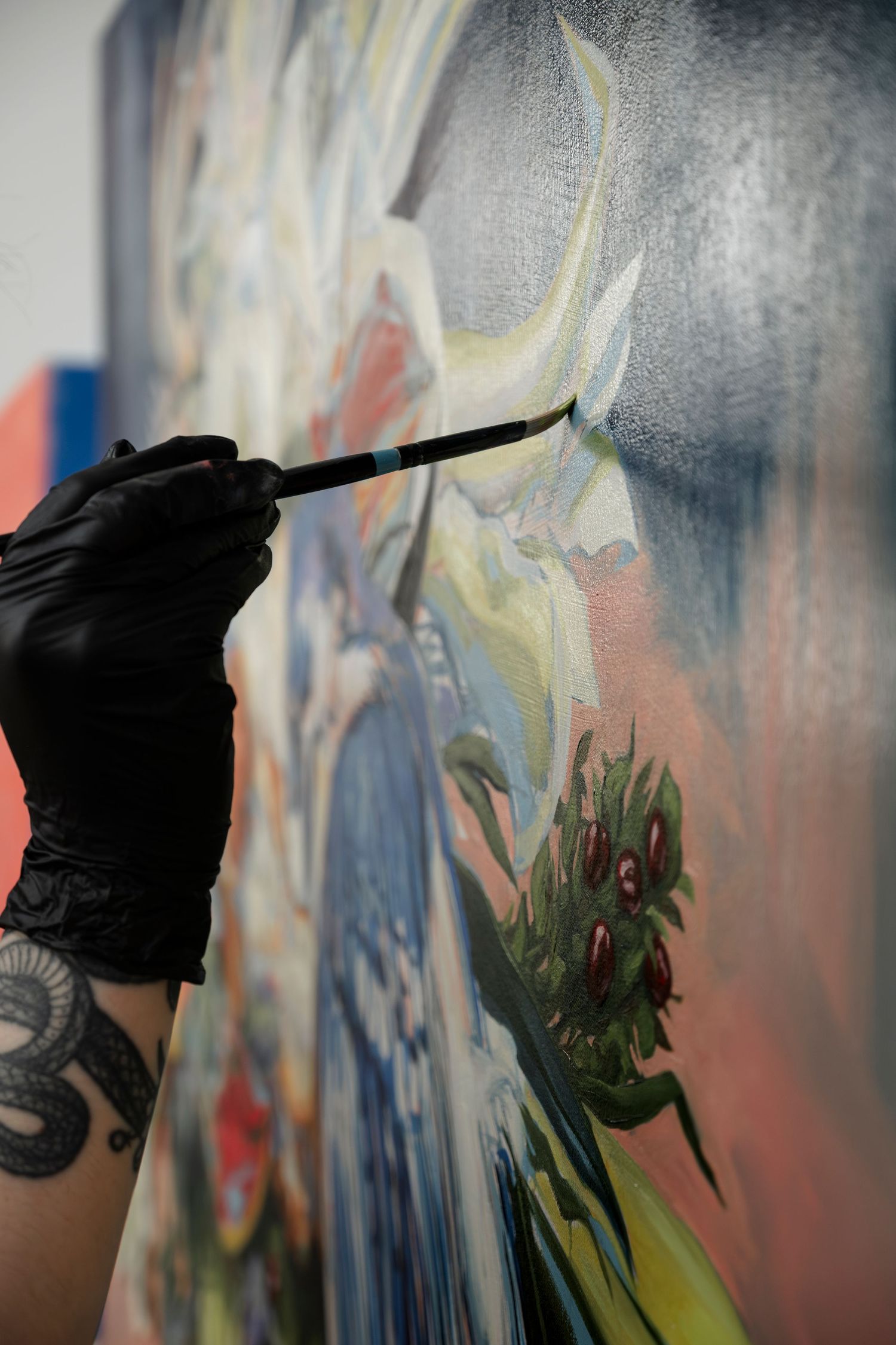 Black gloved hand painting abstract strokes on a textured surface with visible paint drips.