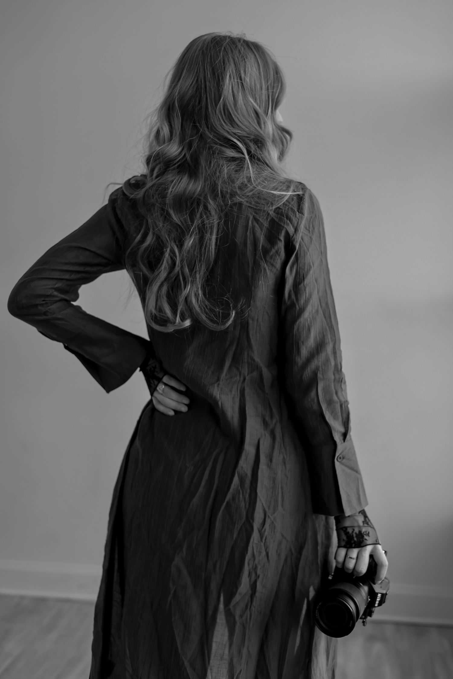 A black and white artistic photo series showing someone in a long dark coat turning away from the camera.