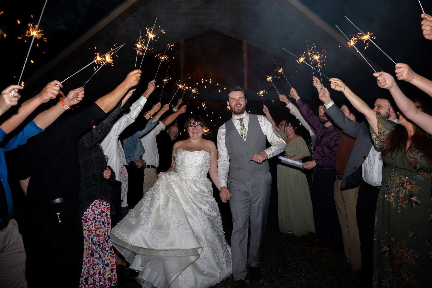 Wedding celebration at night with guests dancing under twinkling lights.