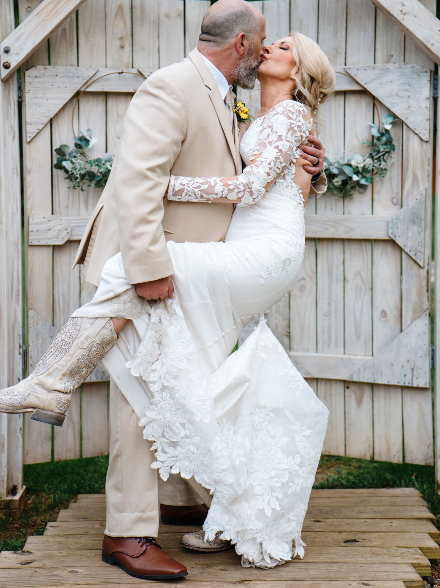 Romantic wedding portraits against a rustic wooden fence with delicate lace details.