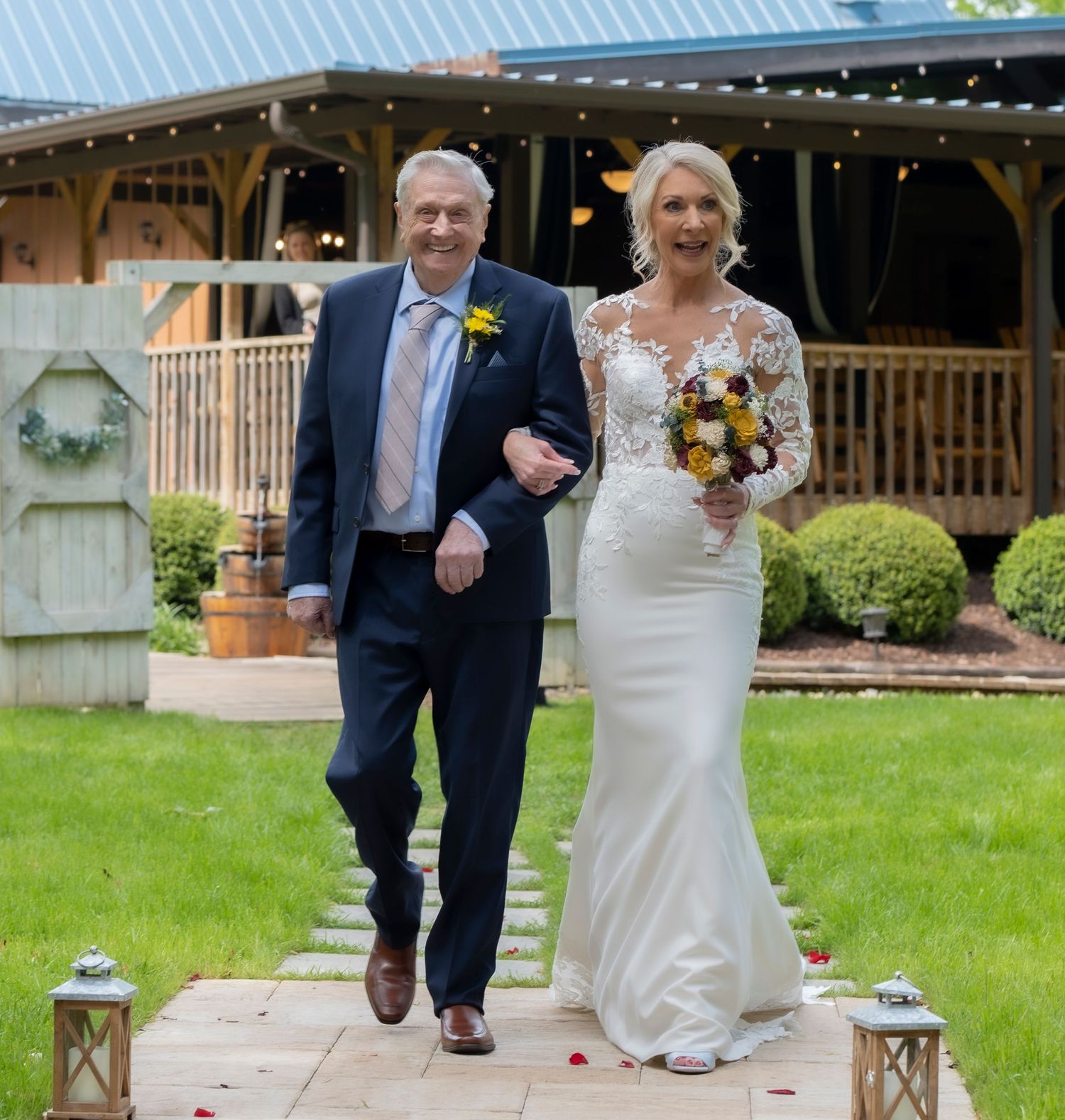 A couple walks together on garden path during their wedding ceremony.