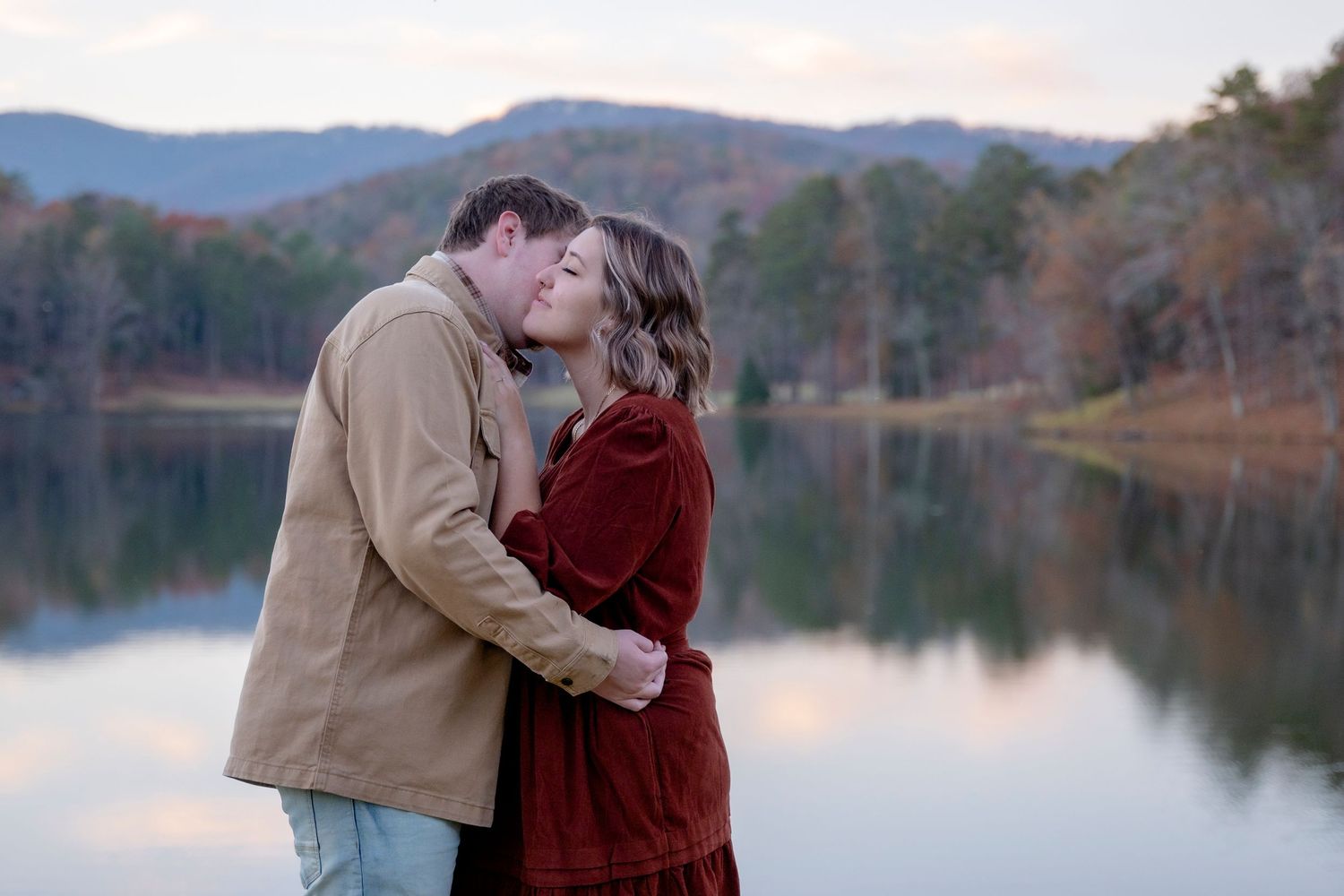 A romantic scene unfolds against the backdrop of a peaceful mountain lake.