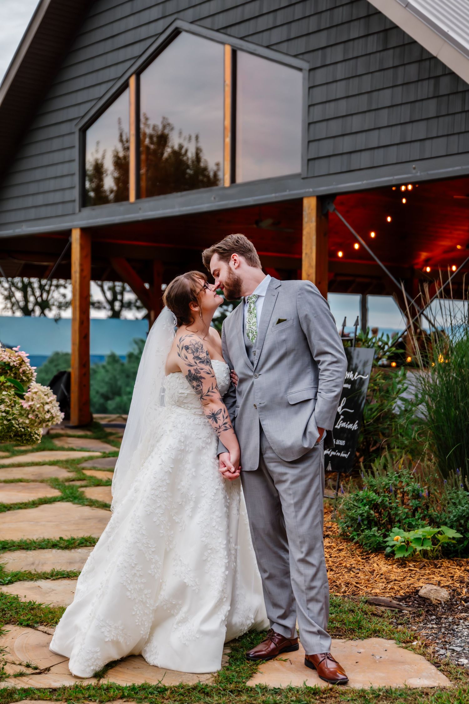 Romantic sunset wedding portraits taken outside a modern gray house with mountain views.