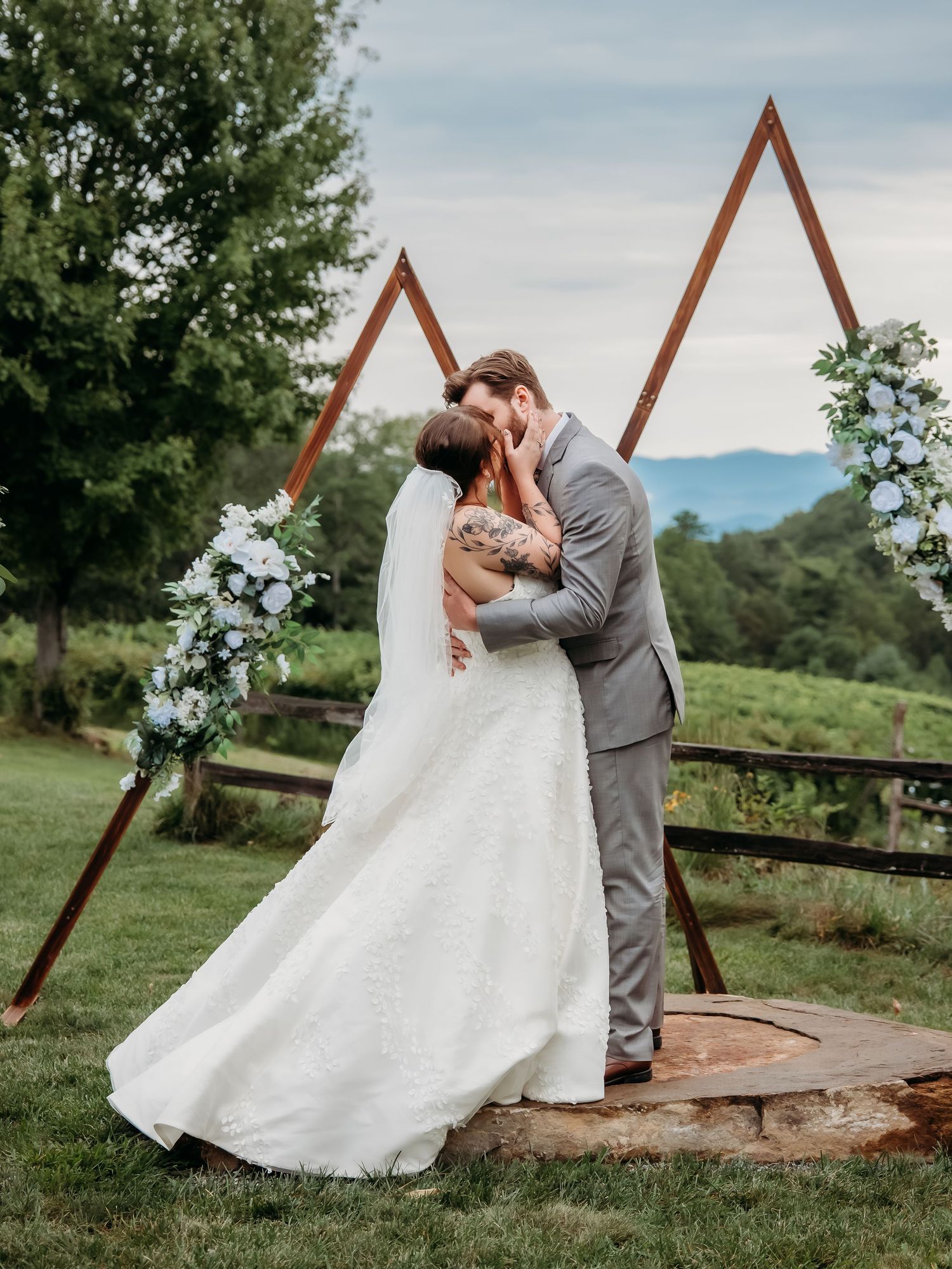 Series of romantic wedding photos captured by a wooden triangle arch with mountain views.