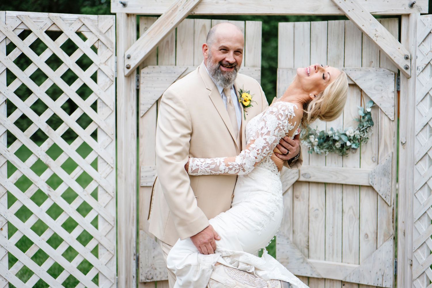 Intimate wedding moments captured against white lattice backdrop with floral accents.