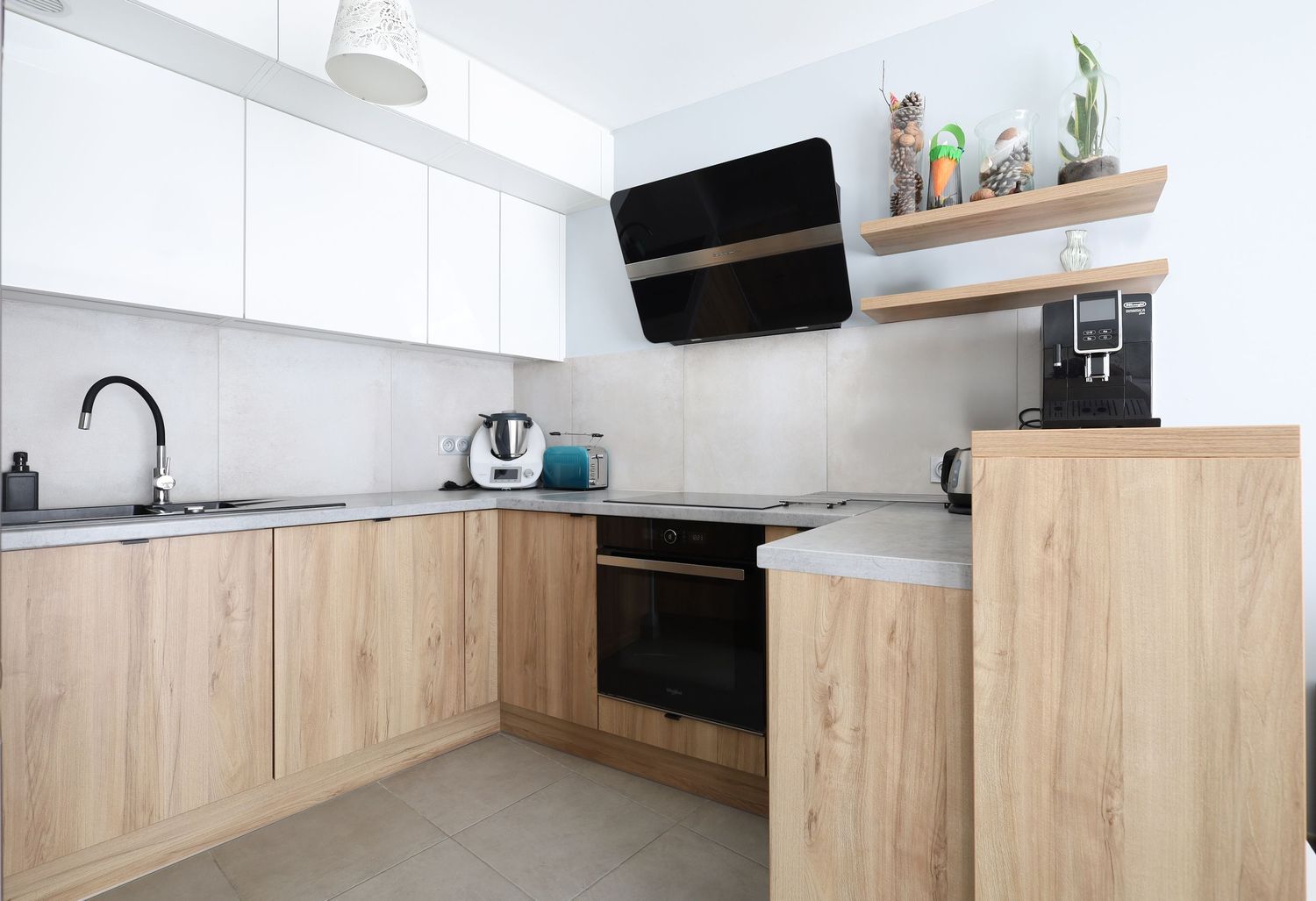 Contemporary L-shaped kitchen with wooden lower cabinets, white upper cabinets, and black appliances.