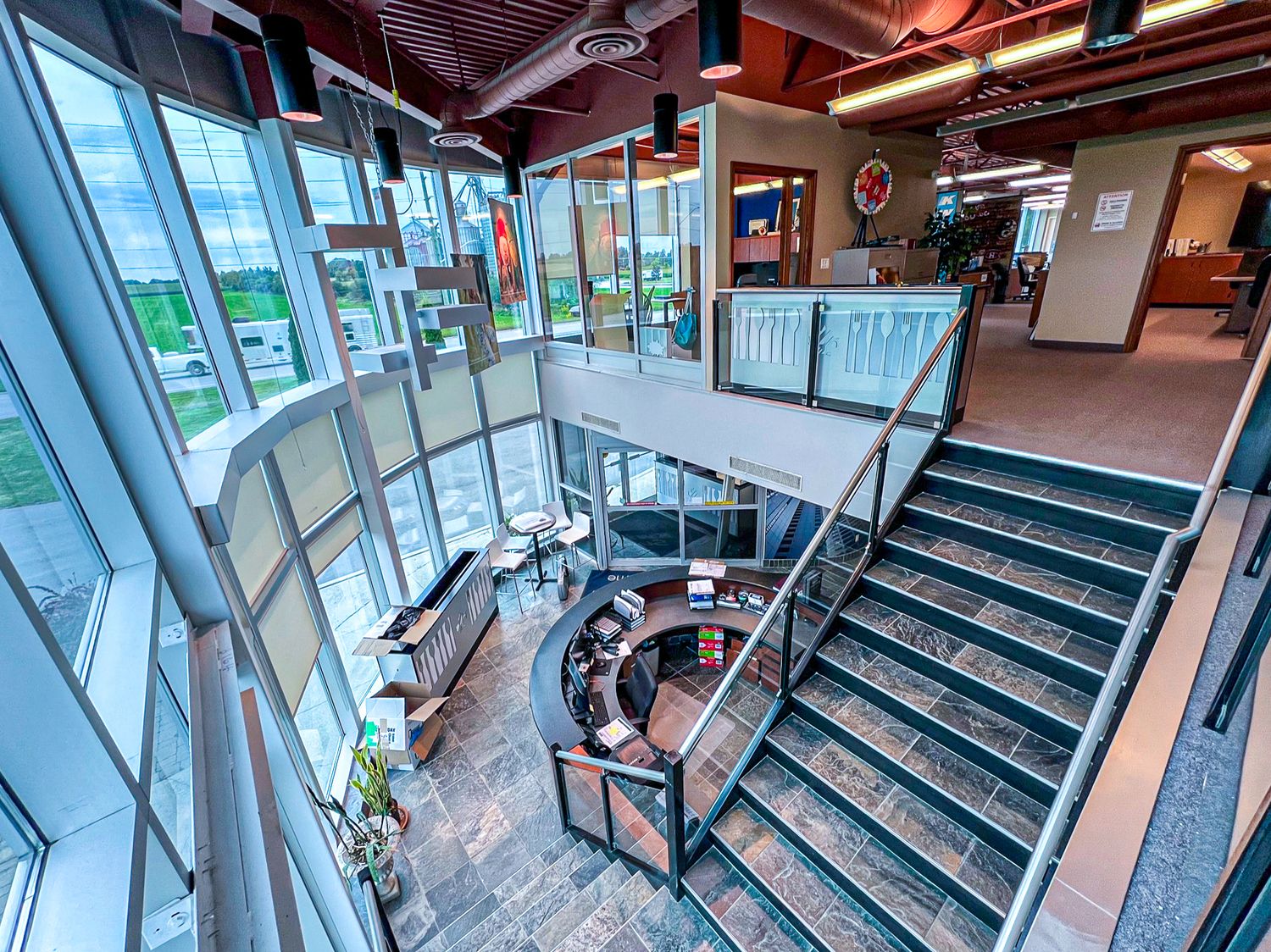 Modern architectural staircase with glass windows and industrial design elements.