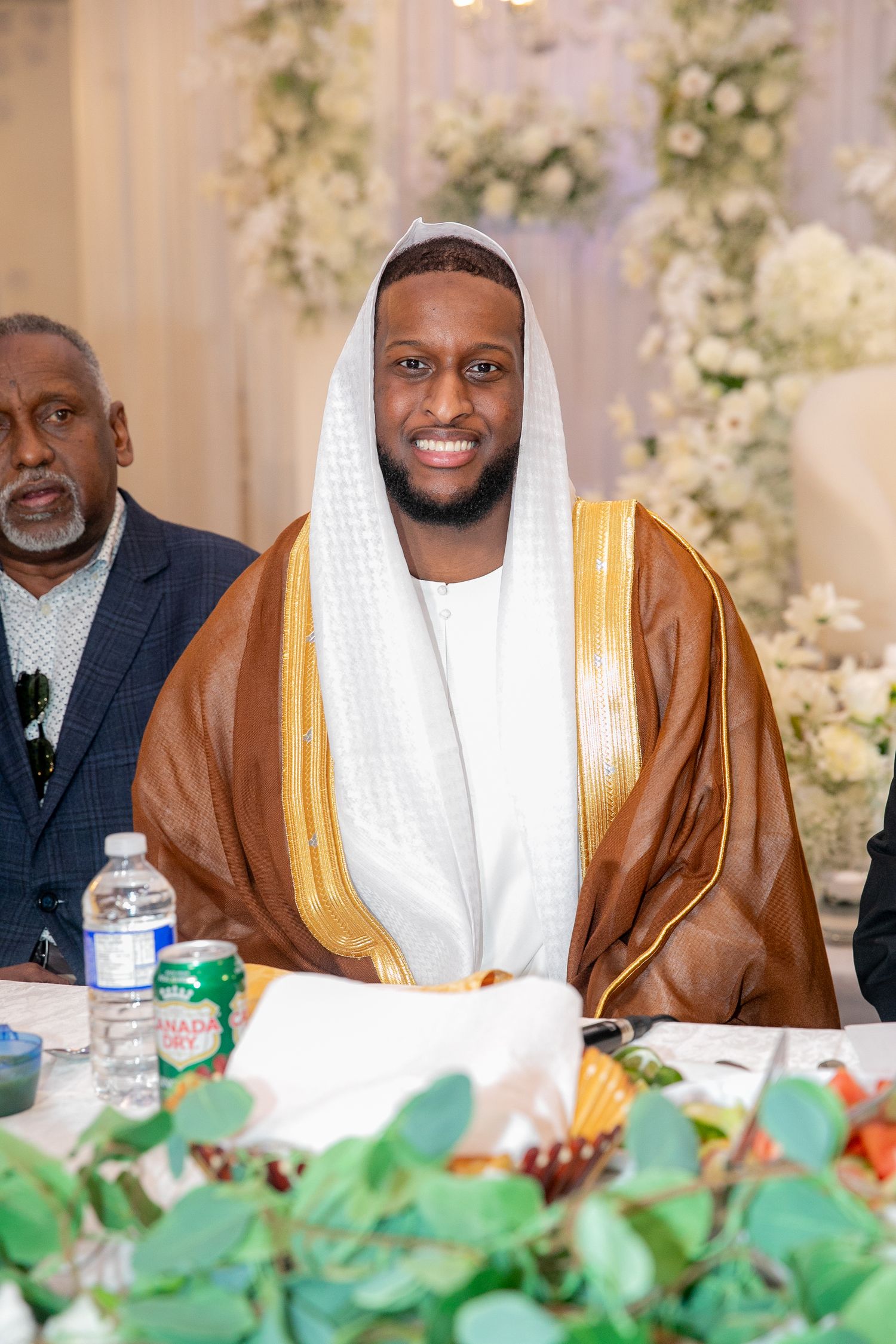 Person wearing traditional Middle Eastern formal attire at decorated event table.