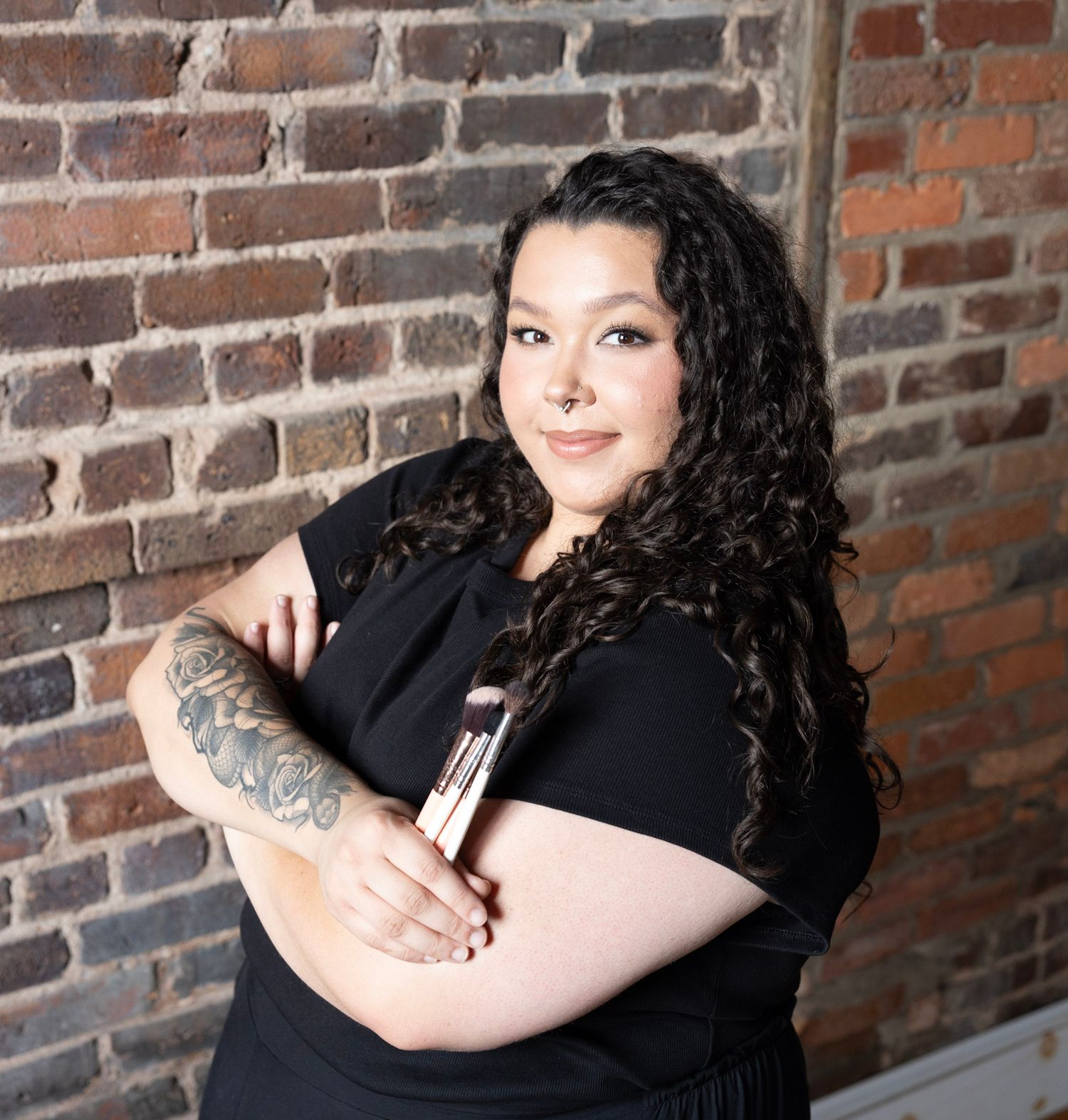 Portrait session featuring casual poses and tattoo art against rustic brick background.