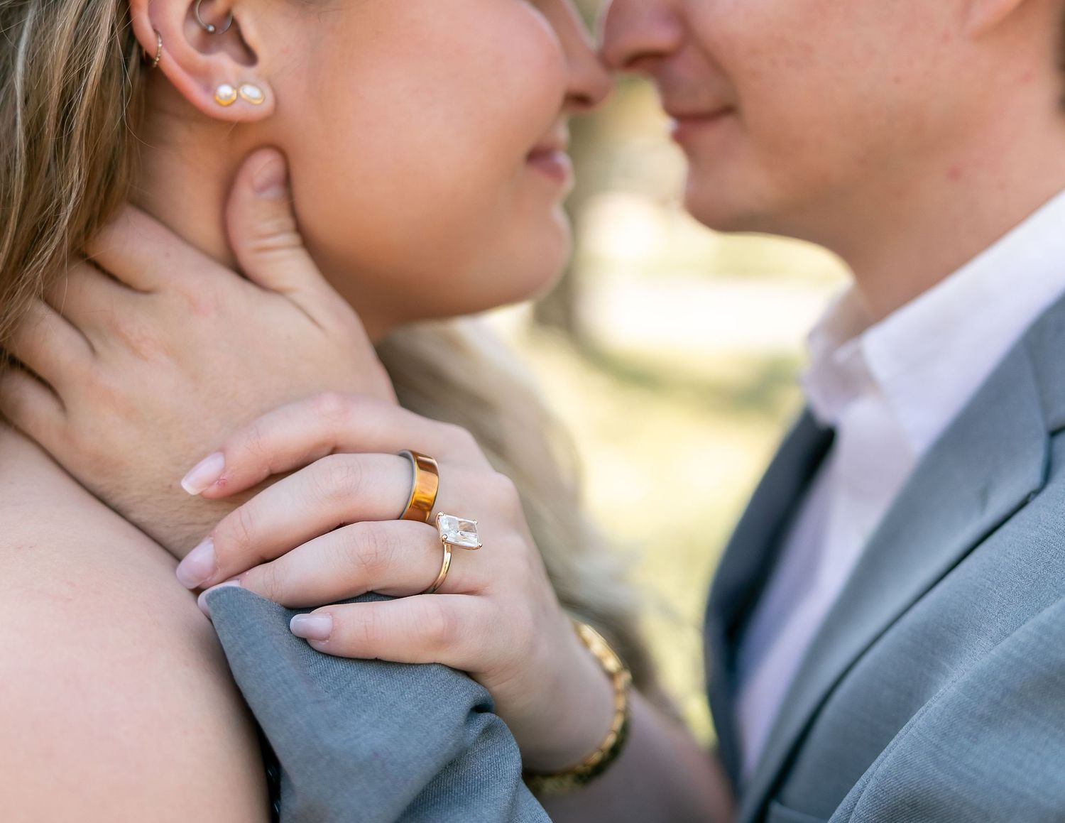 Close up details of hands and rings during an intimate outdoor wedding photo session in warm sunlight.