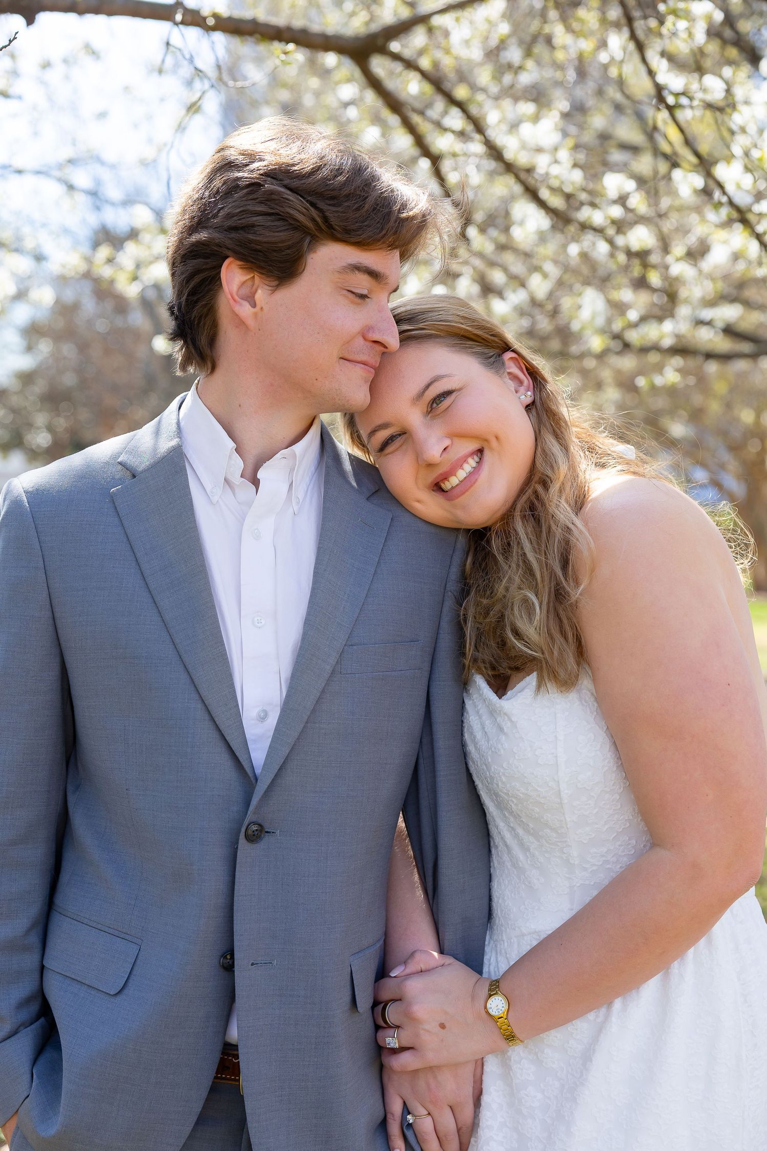A couple shares intimate moments in a series of romantic wedding photos under blooming spring trees.