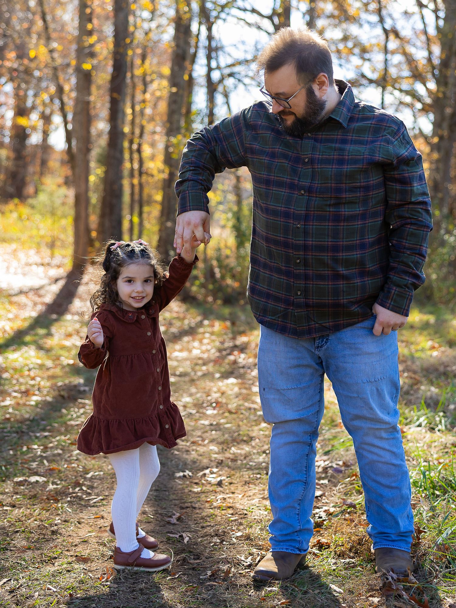 A series of photos showing a touching autumn moment between a parent and child walking together in a wooded area.
