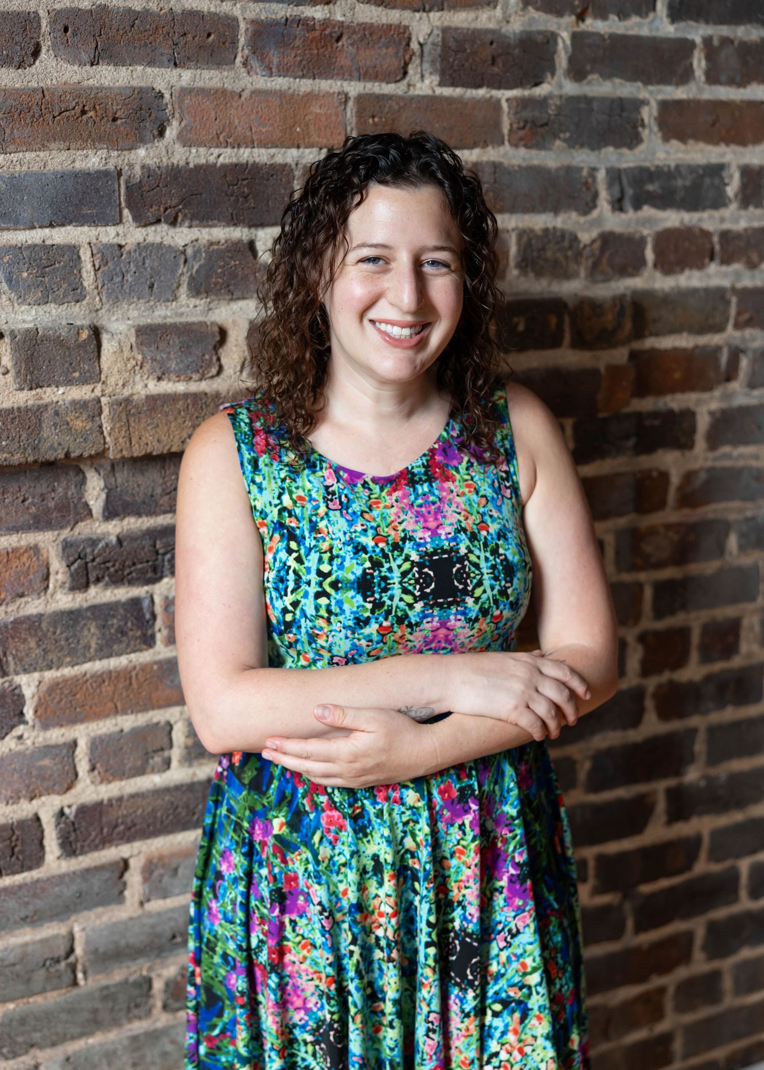 A progressive sequence of portraits against a rustic brick wall showing someone in a vibrant floral print dress.