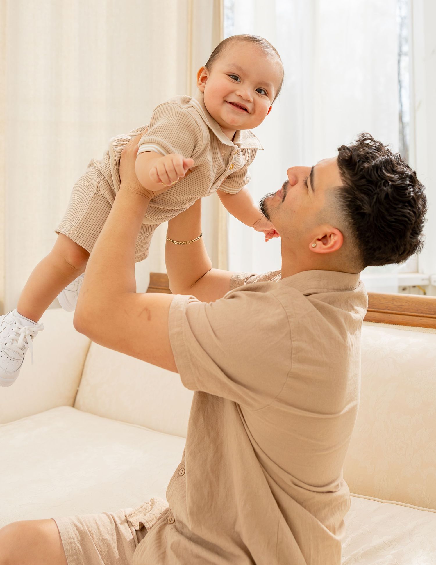 A heartwarming sequence of playful interaction between adult and baby in a bright indoor setting.