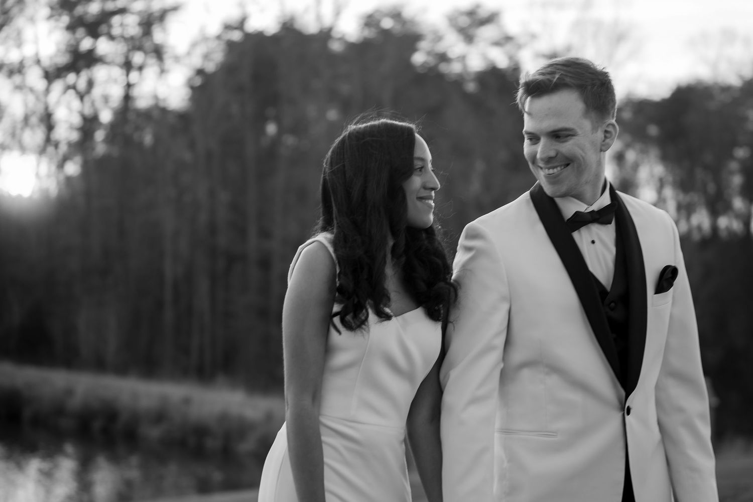 A wedding couple shares a joyful moment together while walking outdoors in formal attire.
