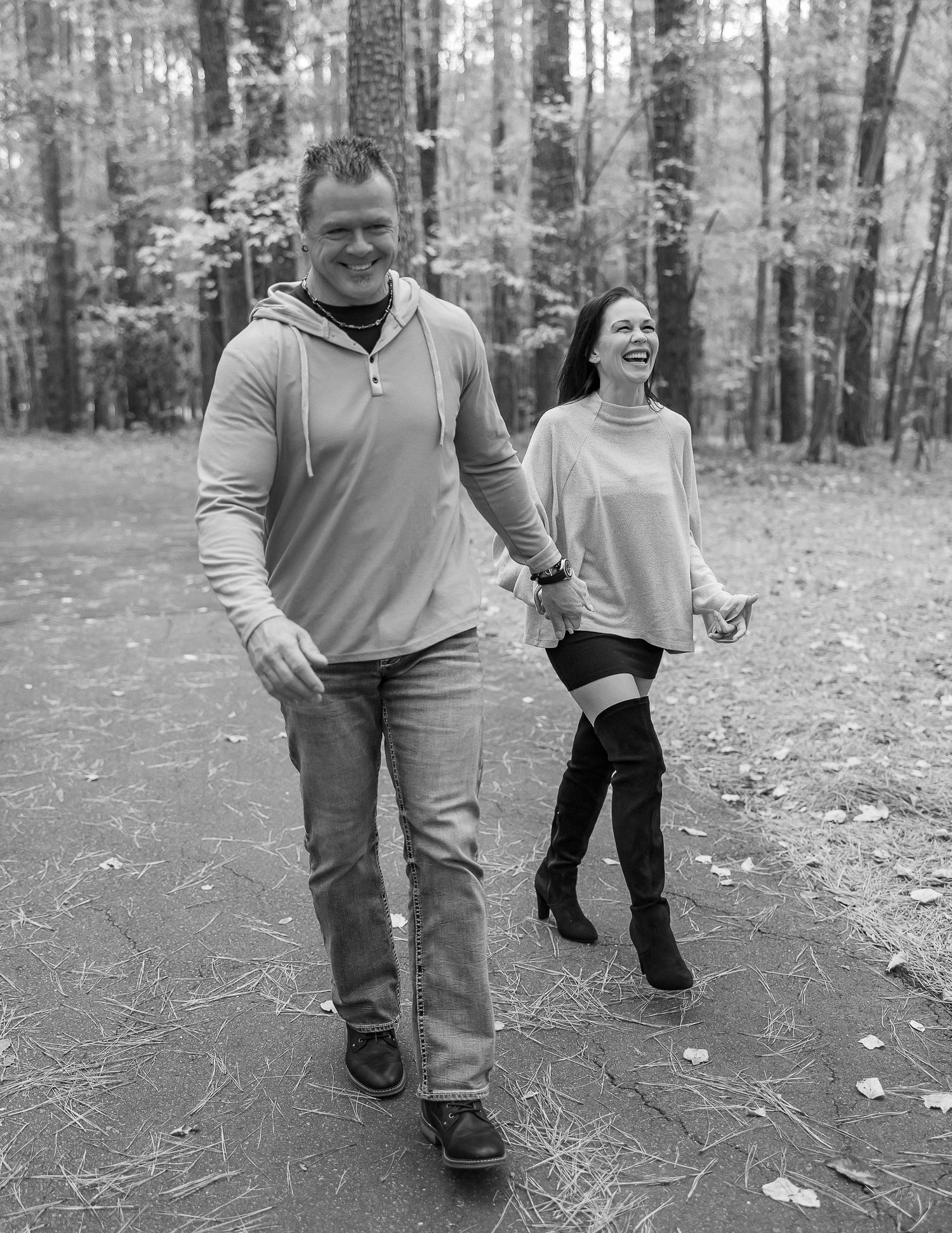 Black and white photo series showing someone walking through fallen leaves in a wooded area.