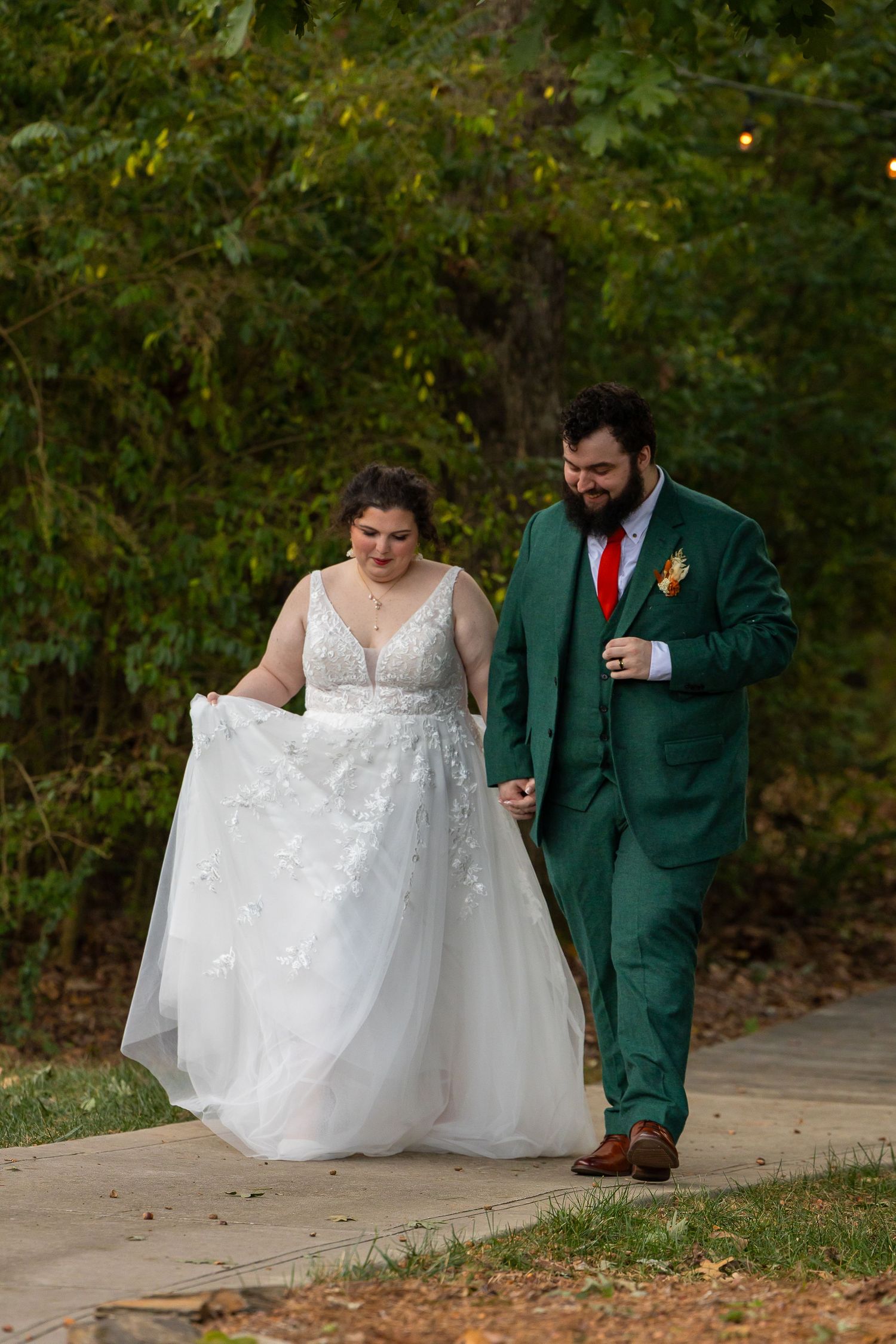 A couple in wedding attire sits together on outdoor steps during an autumn photo session.