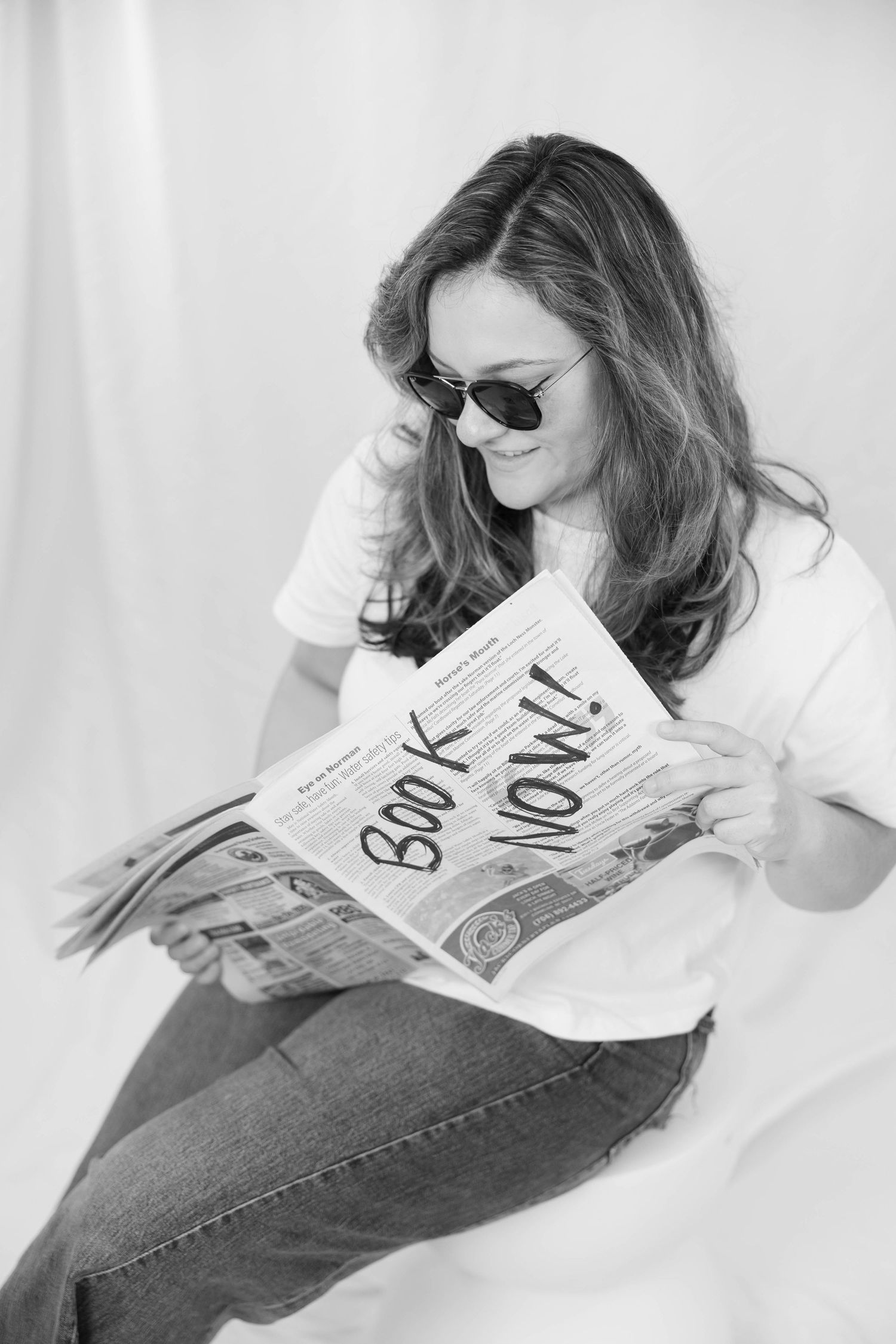 Black and white artistic photo series showing someone relaxing while reading a book on a white backdrop.