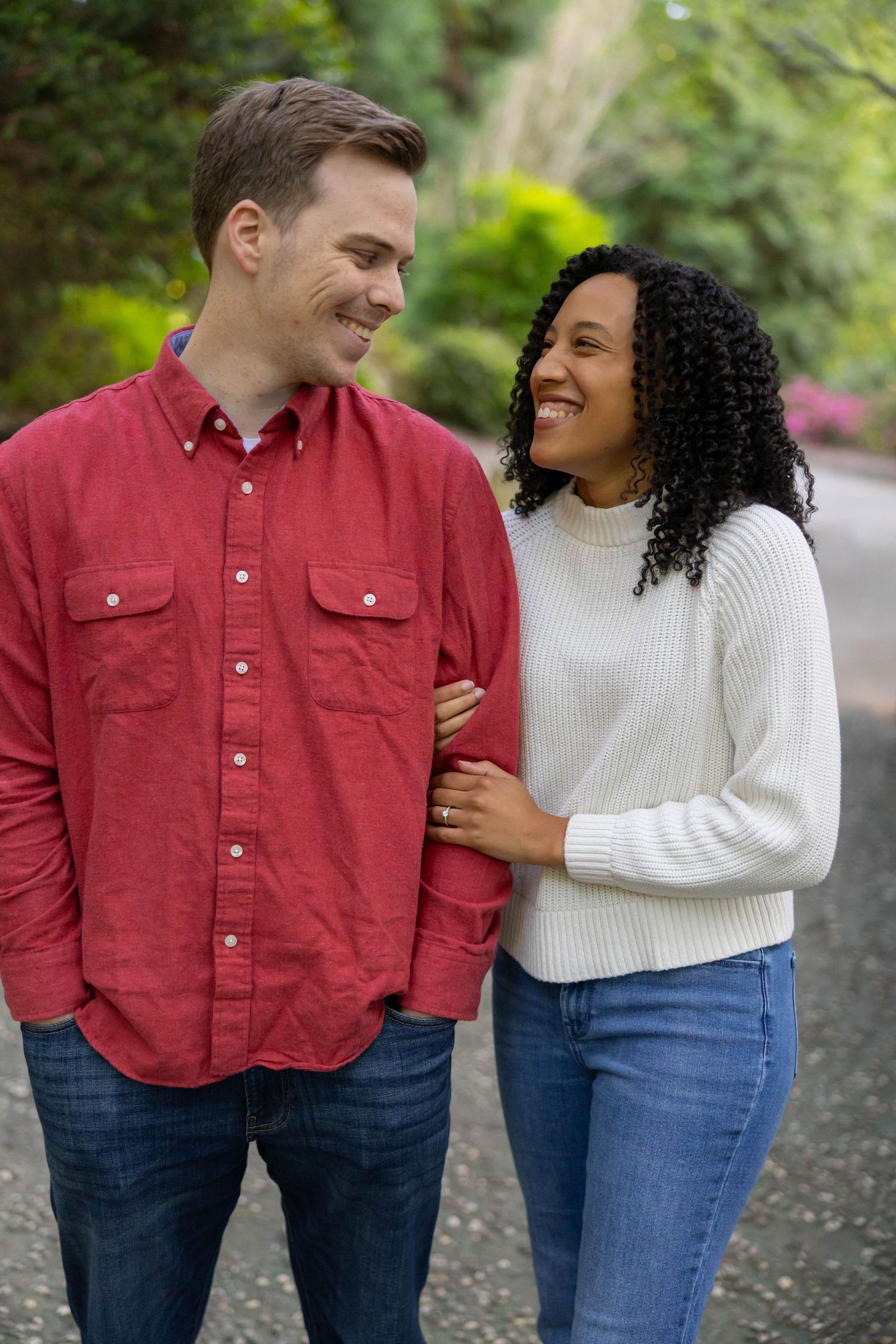 A couple shares a tender moment while walking outdoors, dressed in casual autumn attire.