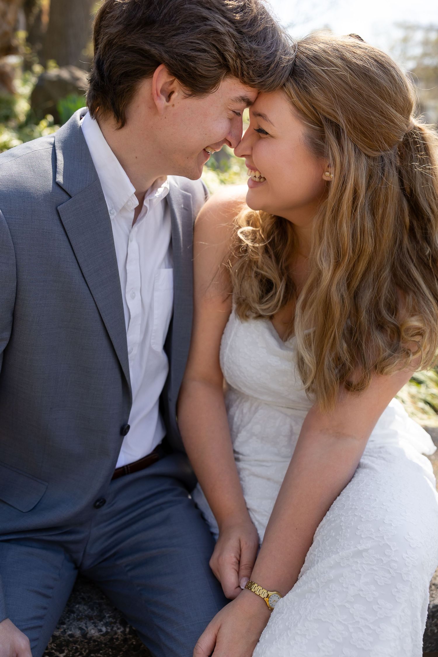 A romantic wedding photo series showing a couple in navy suit and white dress sharing intimate moments in natural light.