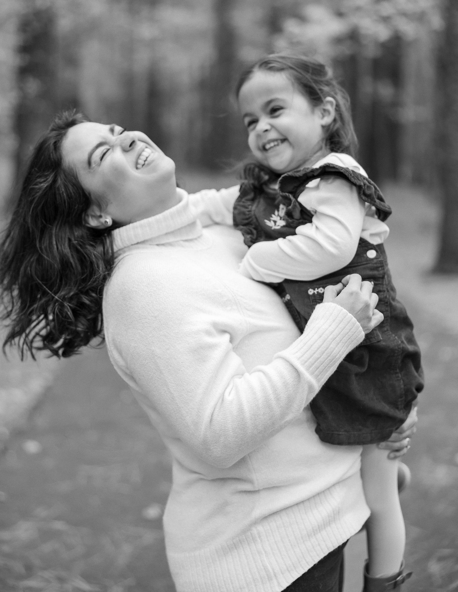 A person in a white sweater joyfully playing with a small brown dog in a series of black and white photos.
