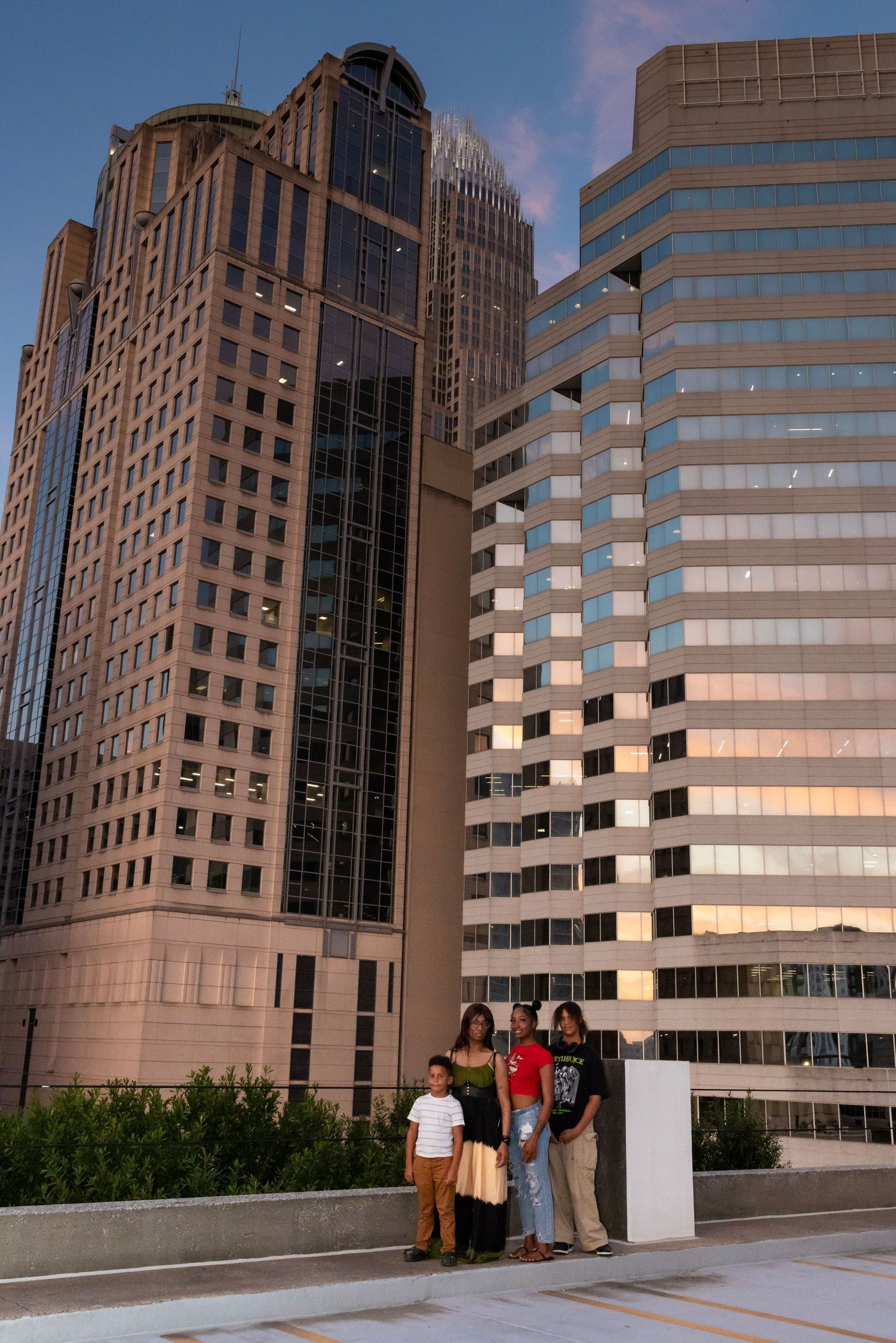 Group standing in front of modern office towers in downtown skyline during golden hour.