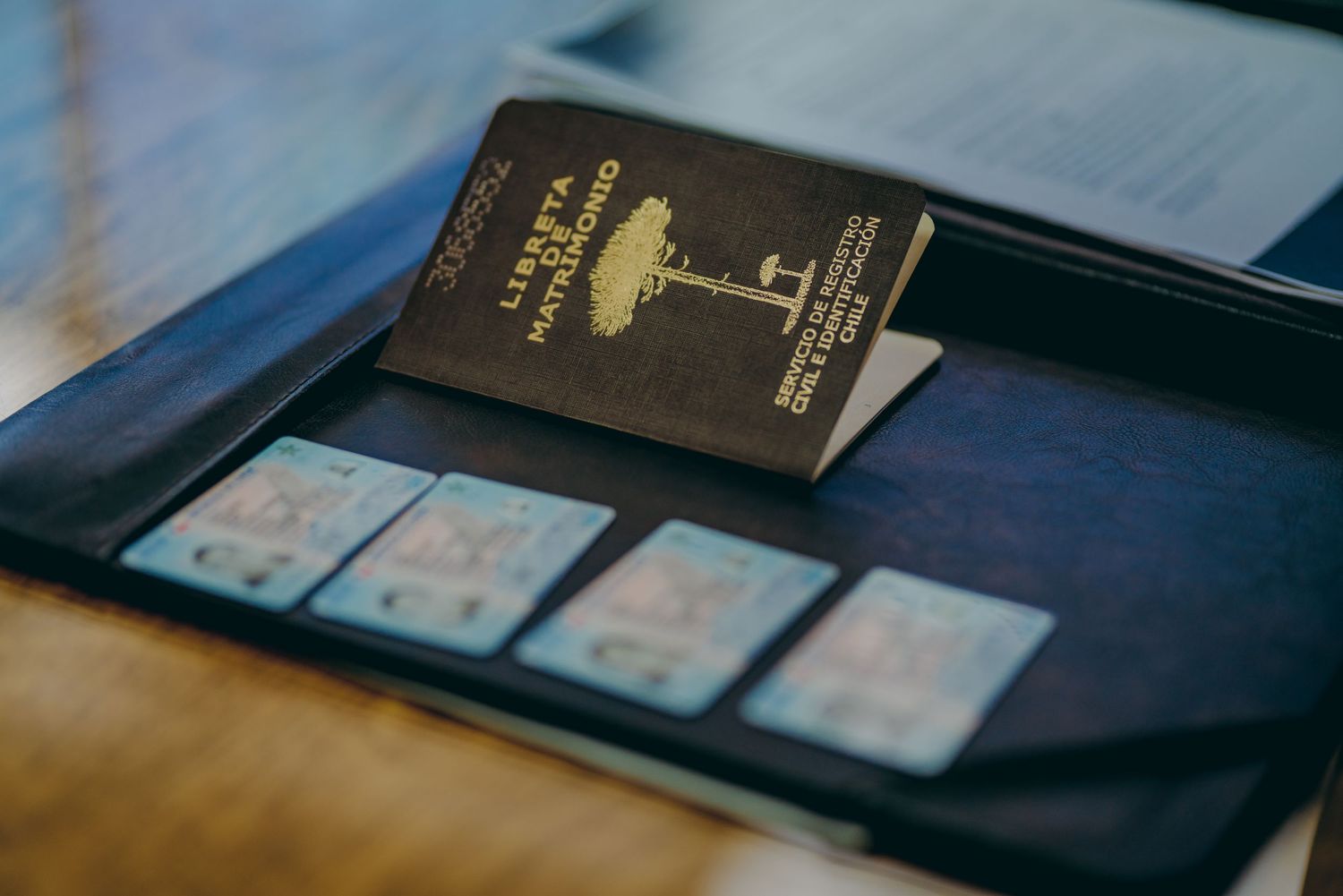 A collection of six cropped photos showing black leather wallets with identification cards and documents displayed.