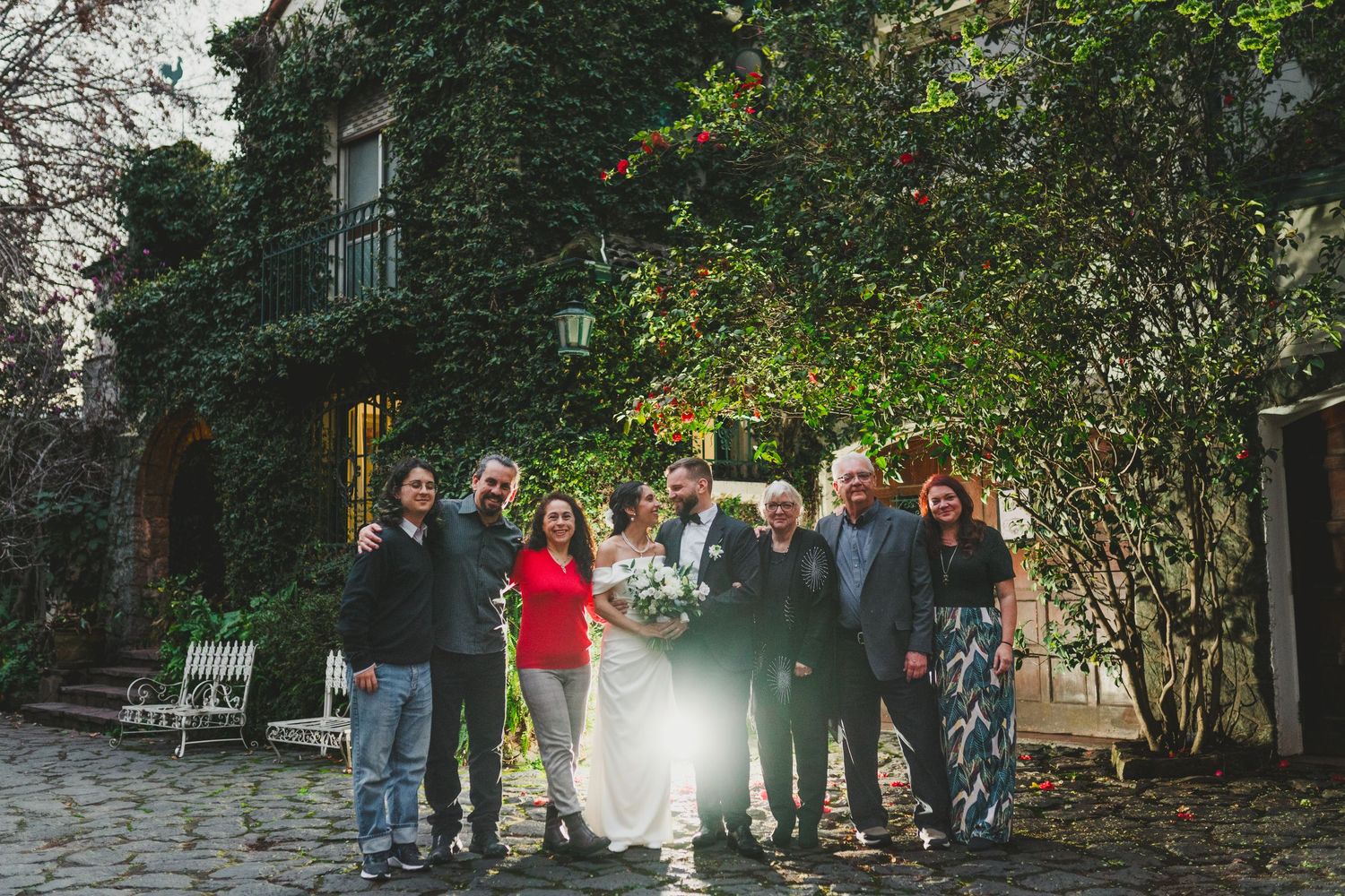 A group stands together outdoors in front of an ivy-covered building on a fall day.
