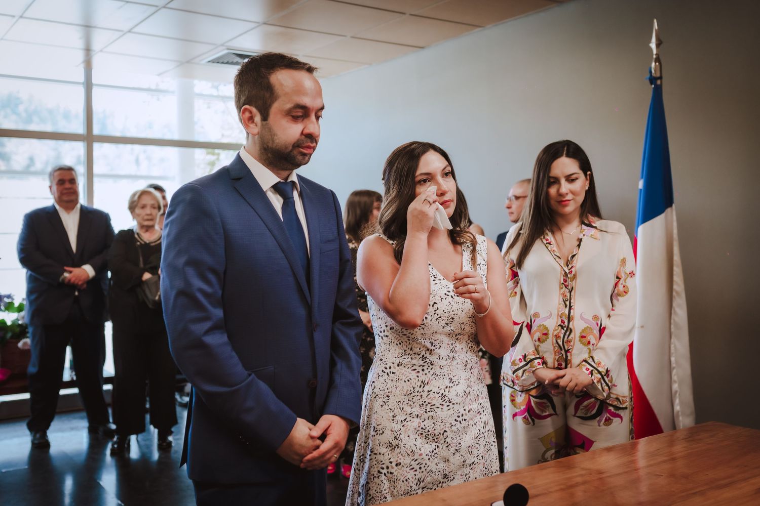 Guest during an indoor wedding ceremony watch as the couple exchanges vows at the altar.