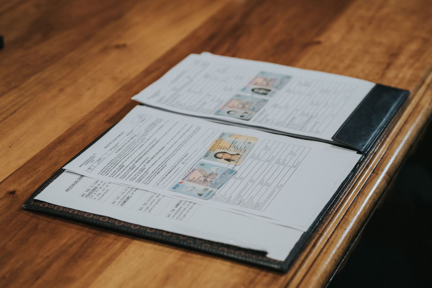 An open restaurant menu with pages laid flat on a wooden table showing food descriptions and prices.