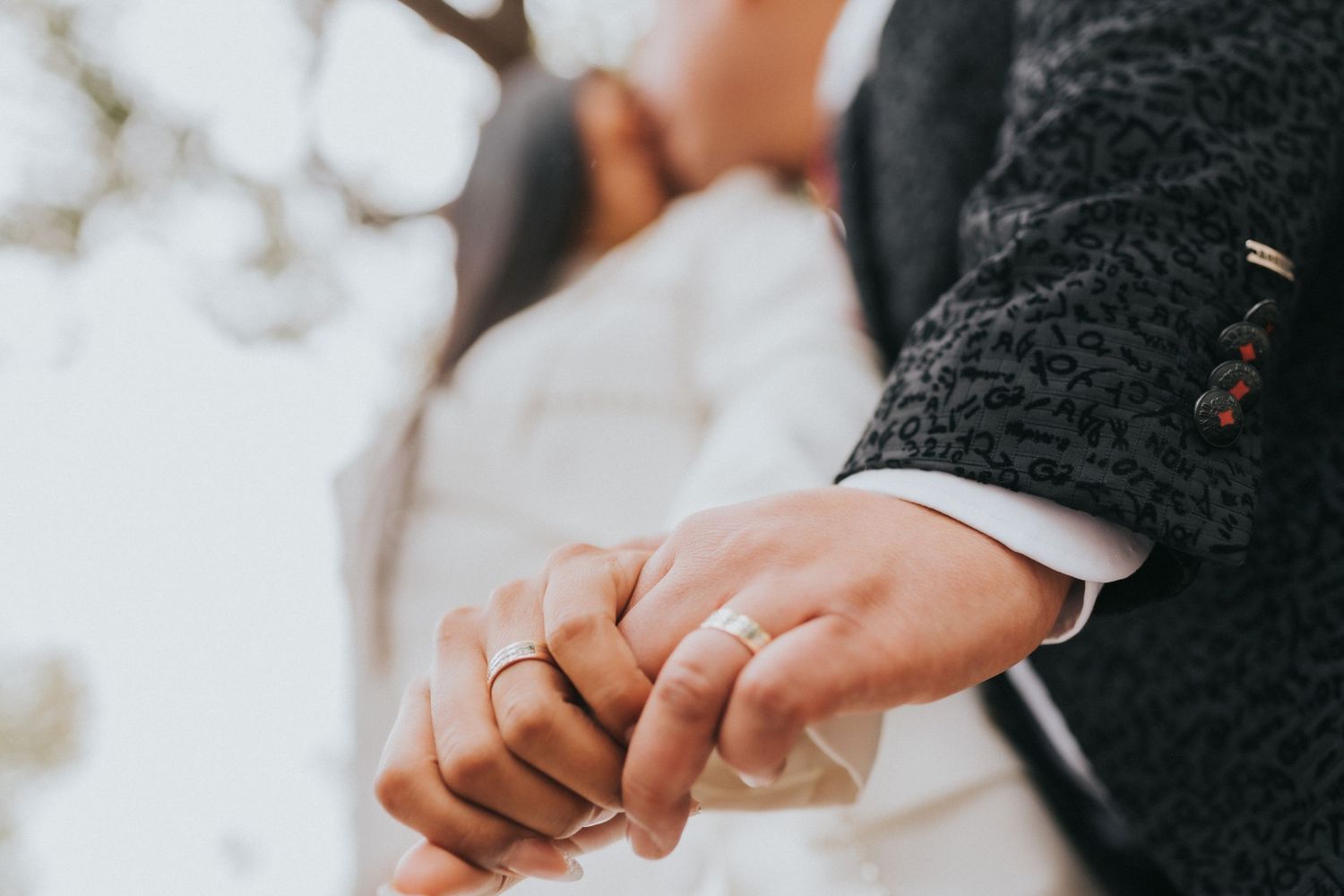 A close-up shot of hands exchanging wedding rings during a ceremony.