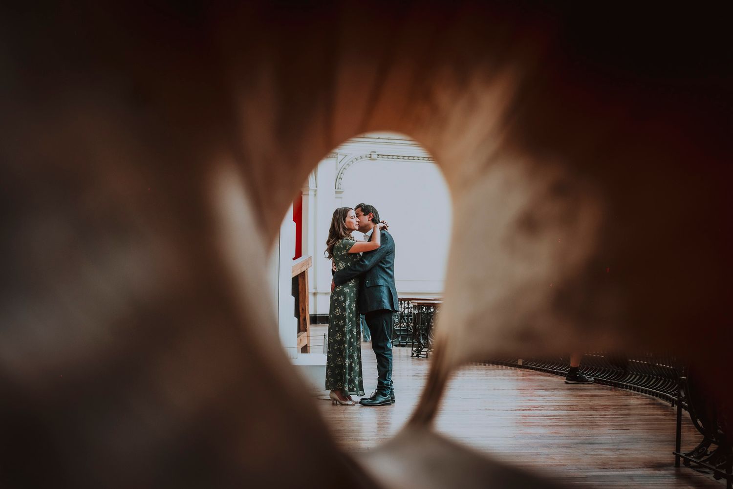 A tender embrace viewed through a keyhole-shaped opening creates an intimate frame.